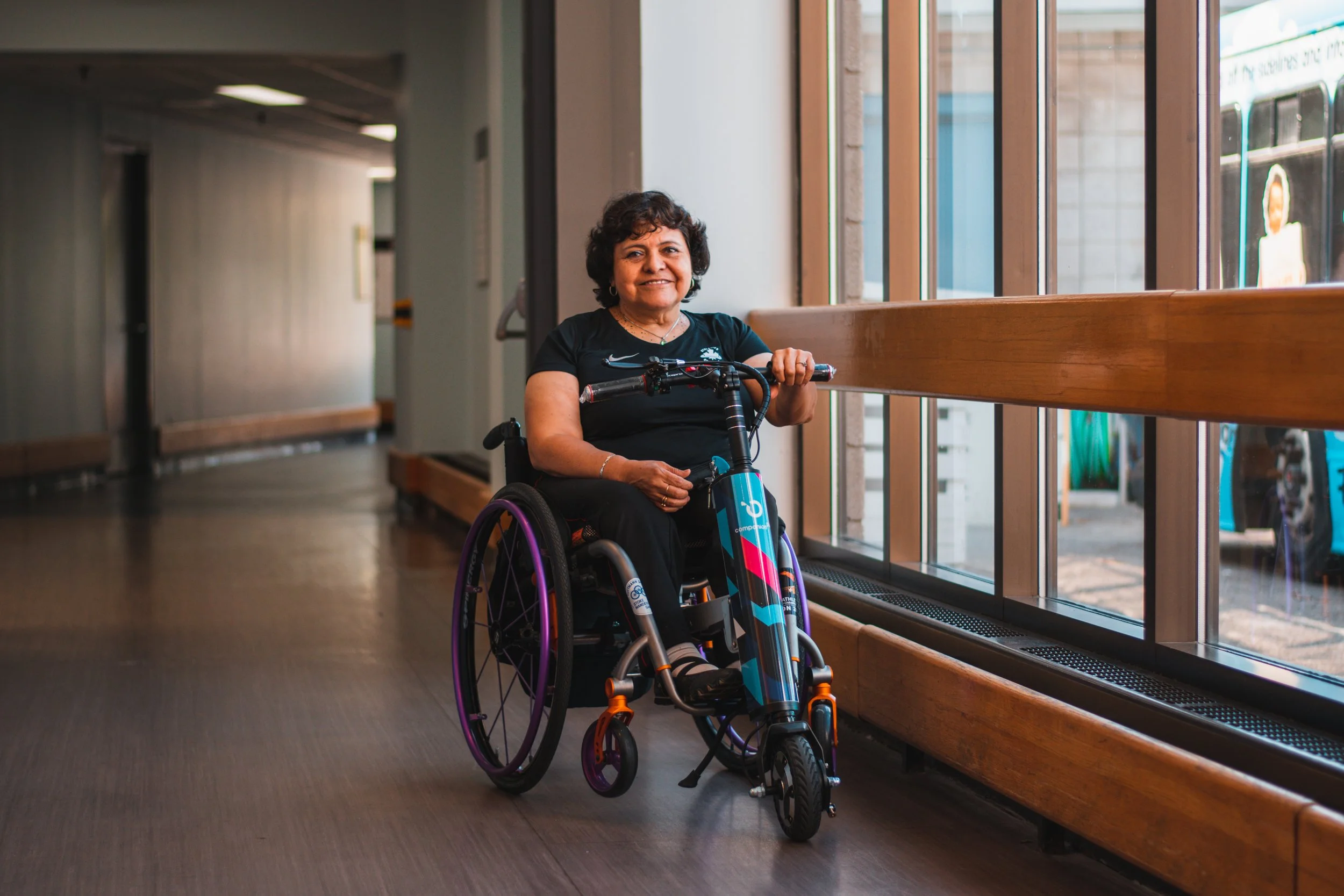 12-time Paralympic medallist Martha Gustafson smiles after receiving her Cheelcare Companion. Cheelcare's motorized device helps those in wheelchairs move around without needing to push their wheels, and became ADP-approved in May. June 3, 2022. (Kaj
