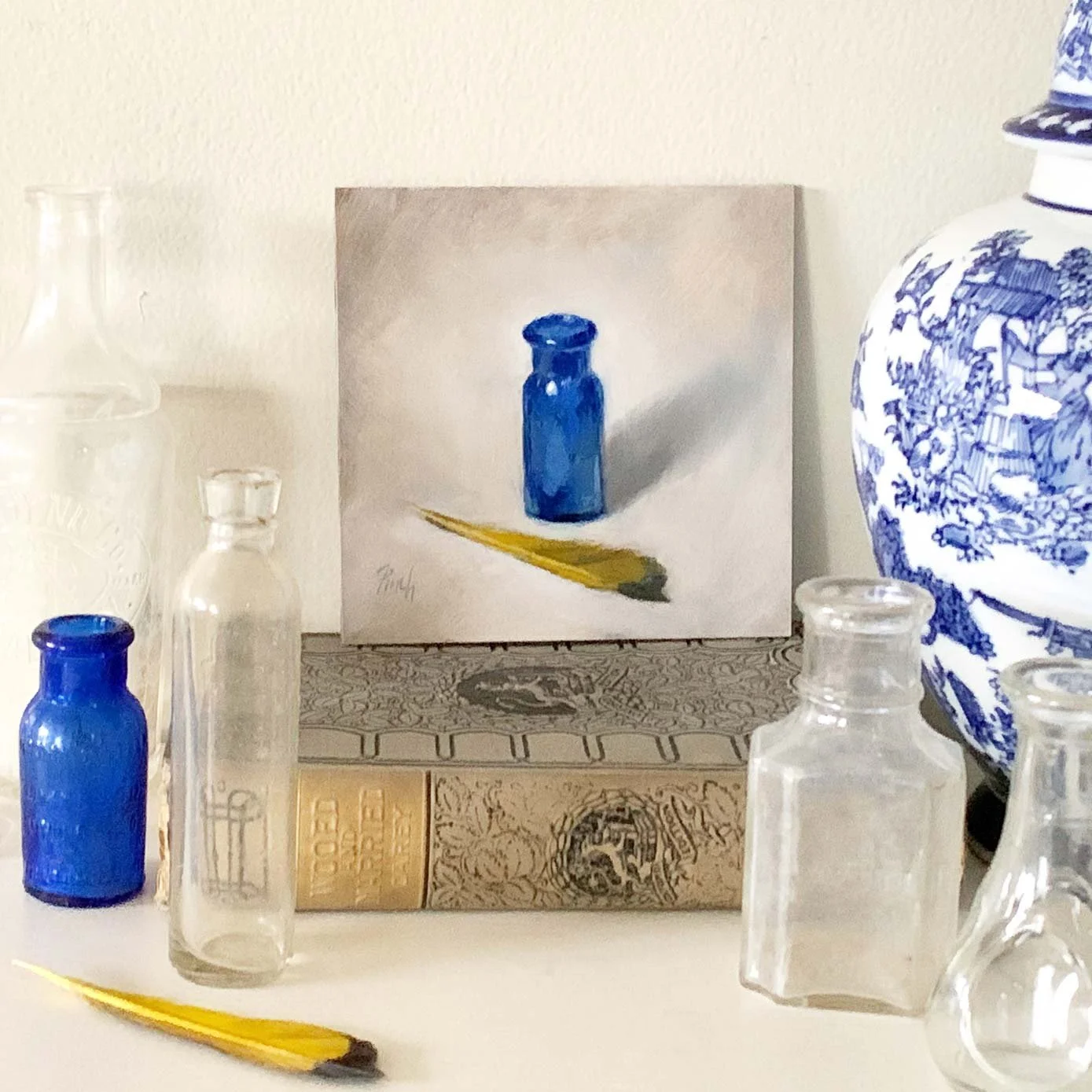 Cobalt-and-Gold-oil-painting-of-a-cobalt-blue-bottle-and-yellow-feather-by-rebecca-finch-fine-art-studios-in-situ.jpg