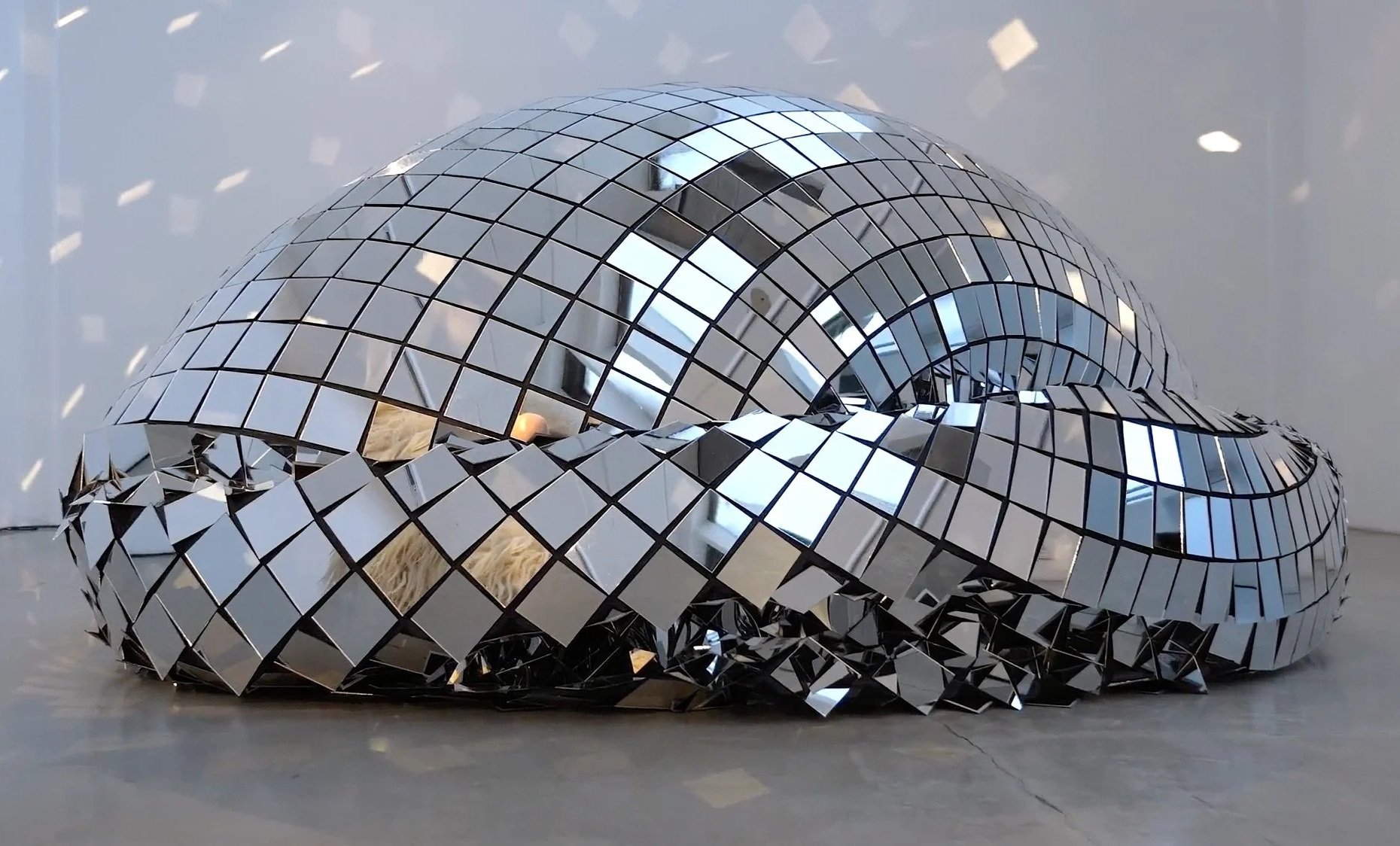 Kunstinstallation aus reflektierenden Spiegeln in der Form einer Schlange oder eines Drachen.