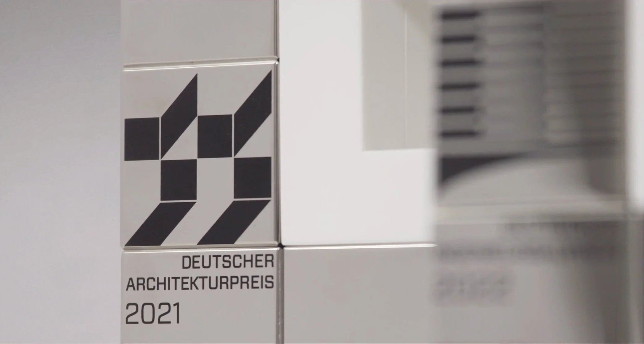 metallene Plakette des Deutschen Architekturpreises 2021 mit schwarzem geometrischem Design