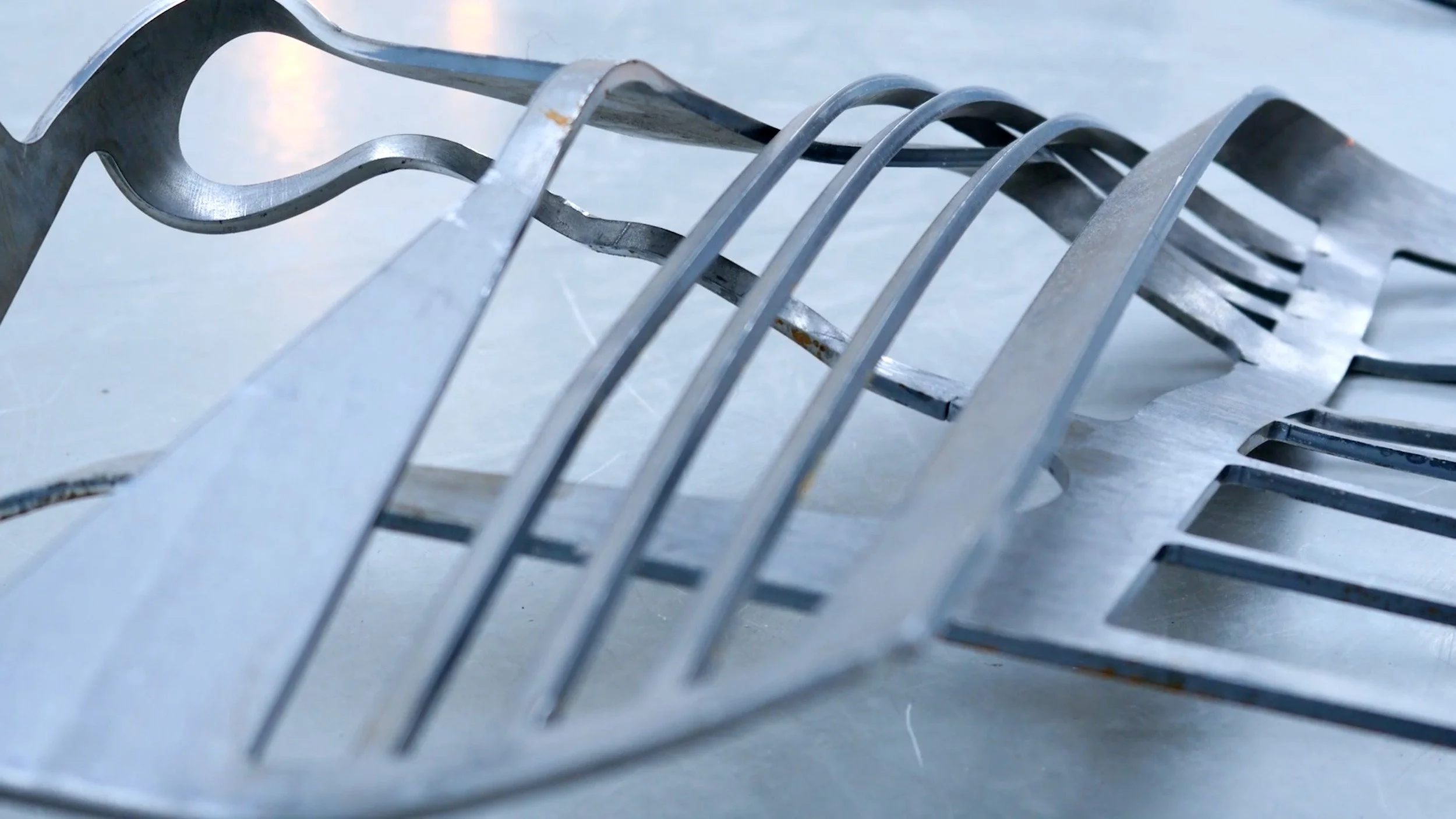 Metallstücke in einer Kunstausstellung, die auf dem Boden liegen.