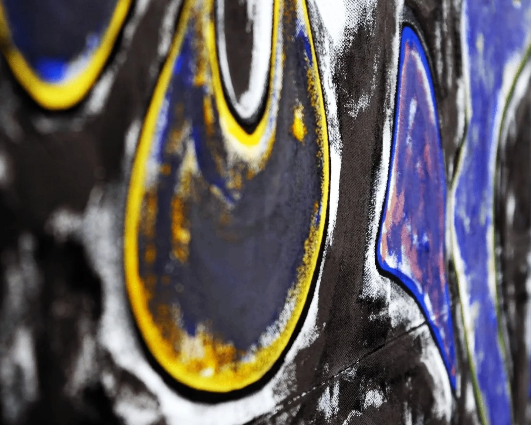 Nahaufnahme eines Kunstwerks mit schwarzen, gelben, blauen und weißen Akzenten auf einer Wand.