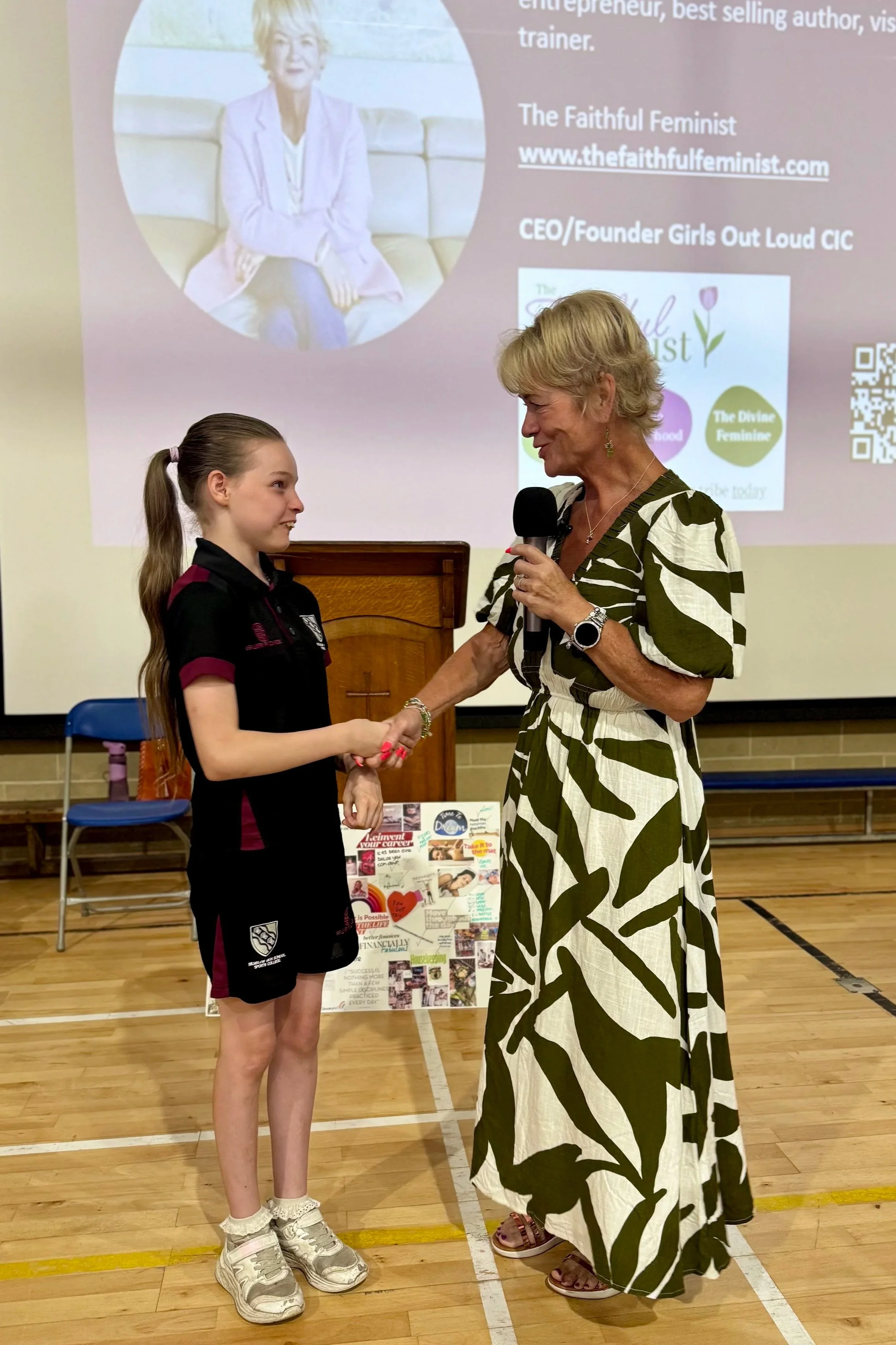 Jane shaking the hand of a young teenage school girl at an event