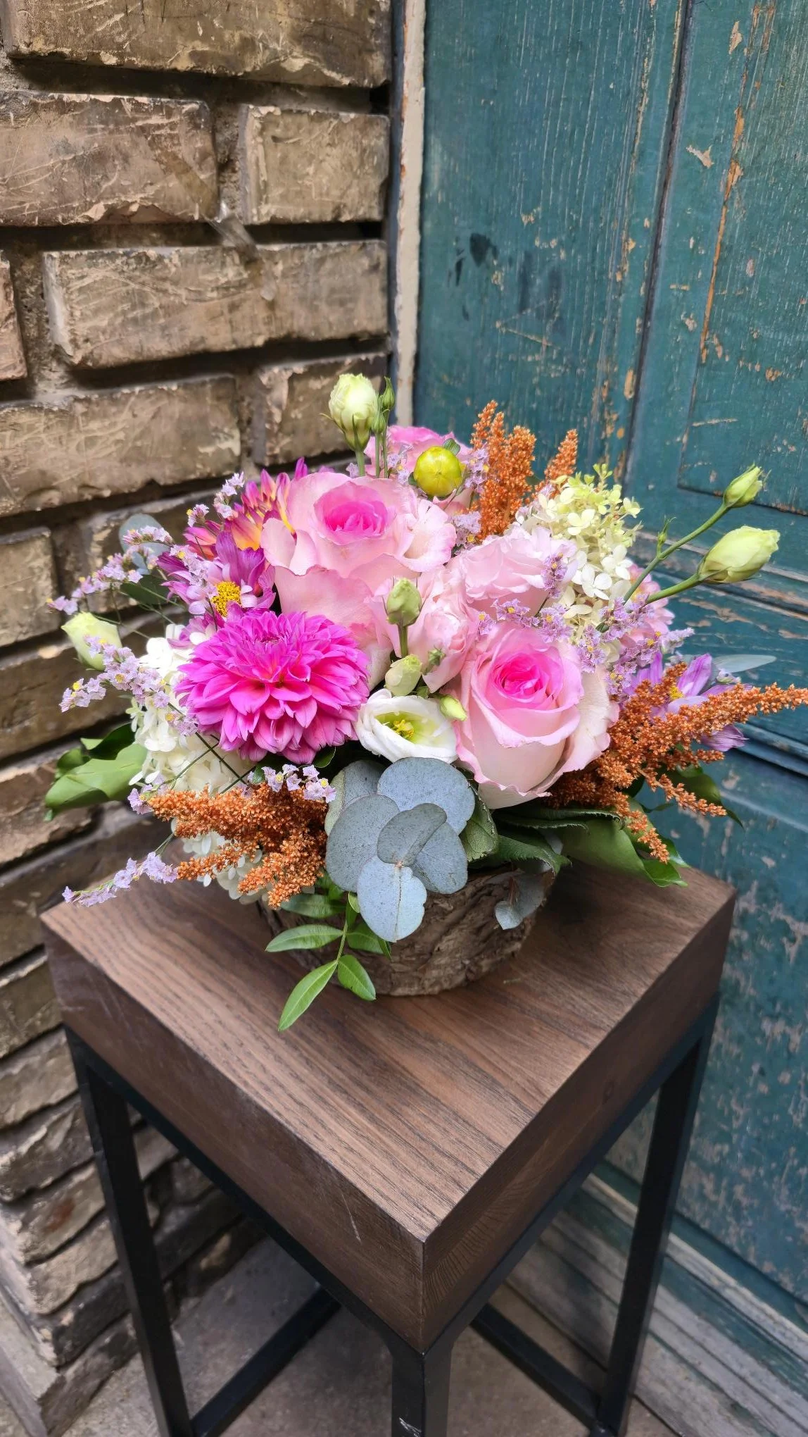 Gesteck aus rosa/ pinken, saisonalen Blumen