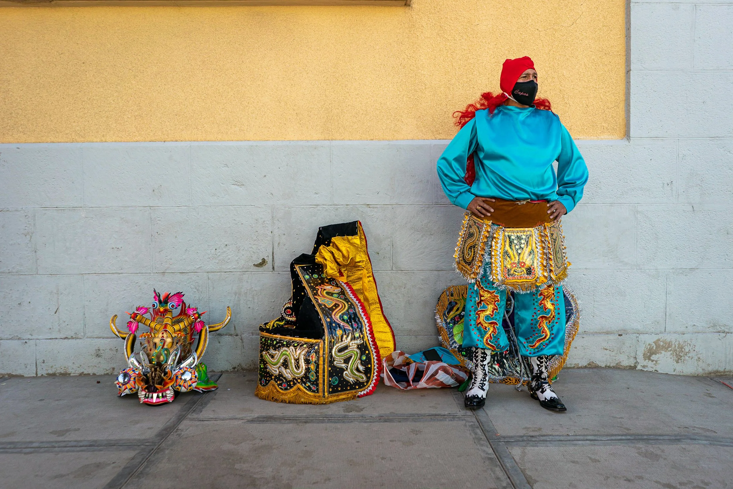 Man with his Diablo costume parts on the pavement during the Peregrinación 