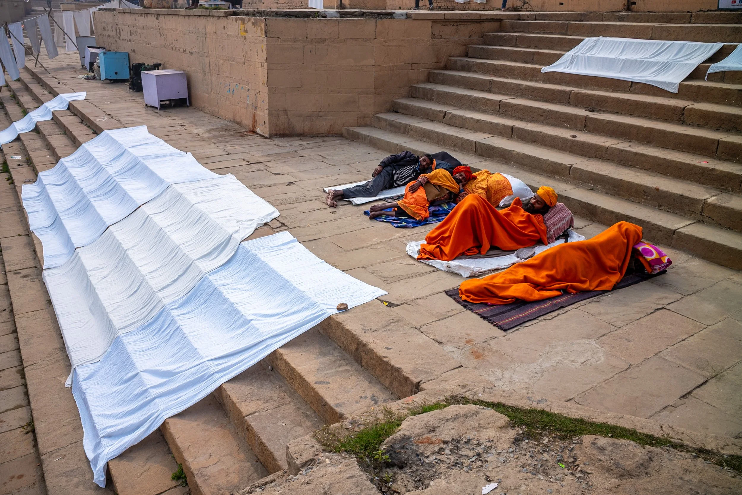 Sadhus sleeping and bed linen drying on ghat in Varanasi