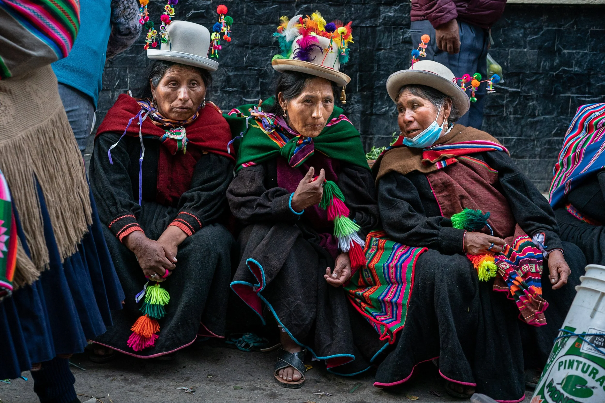 Three women sitting and gossiping during Andean Anata