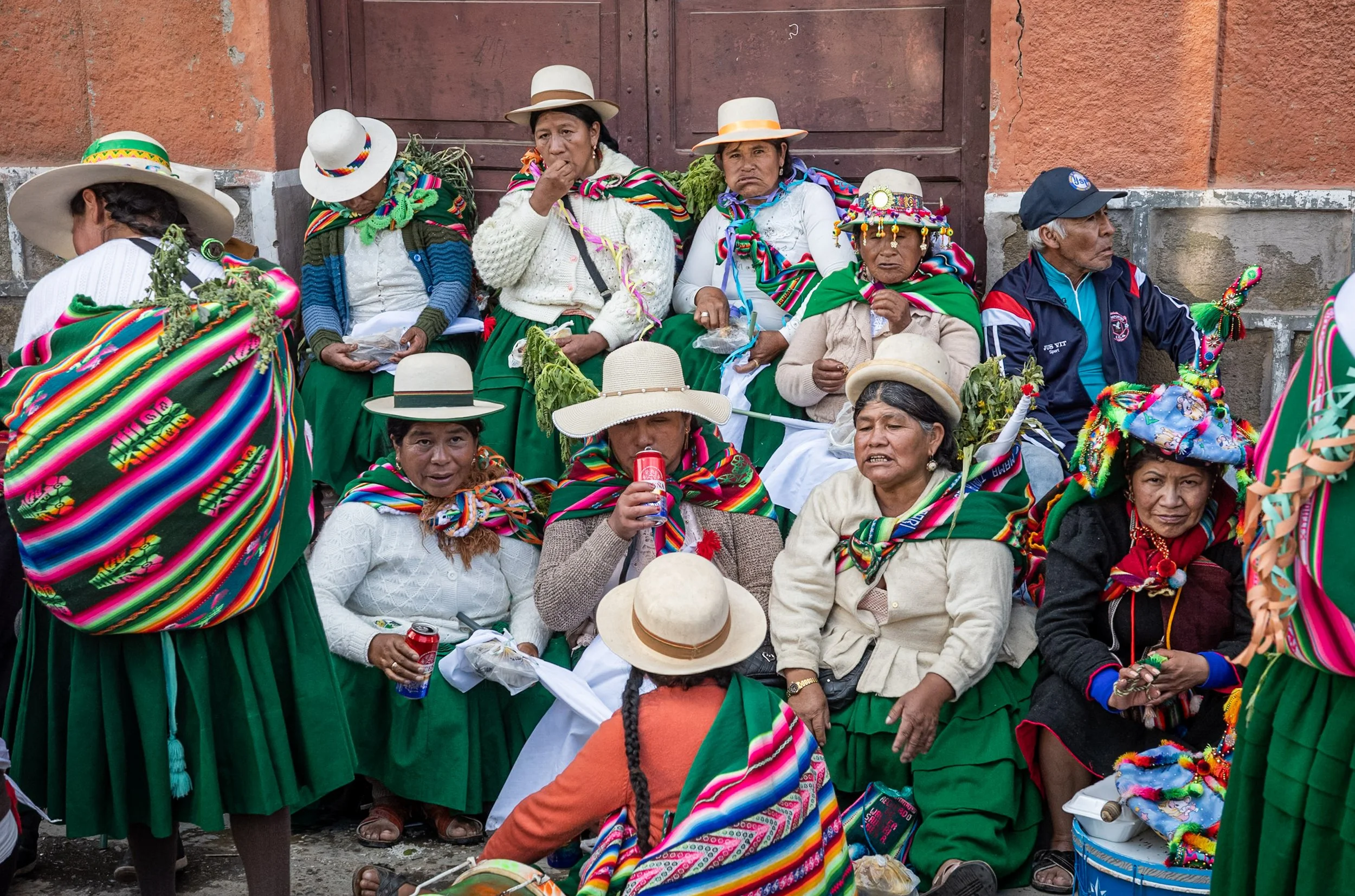 Group of women in white and green resting after Andean Anata 