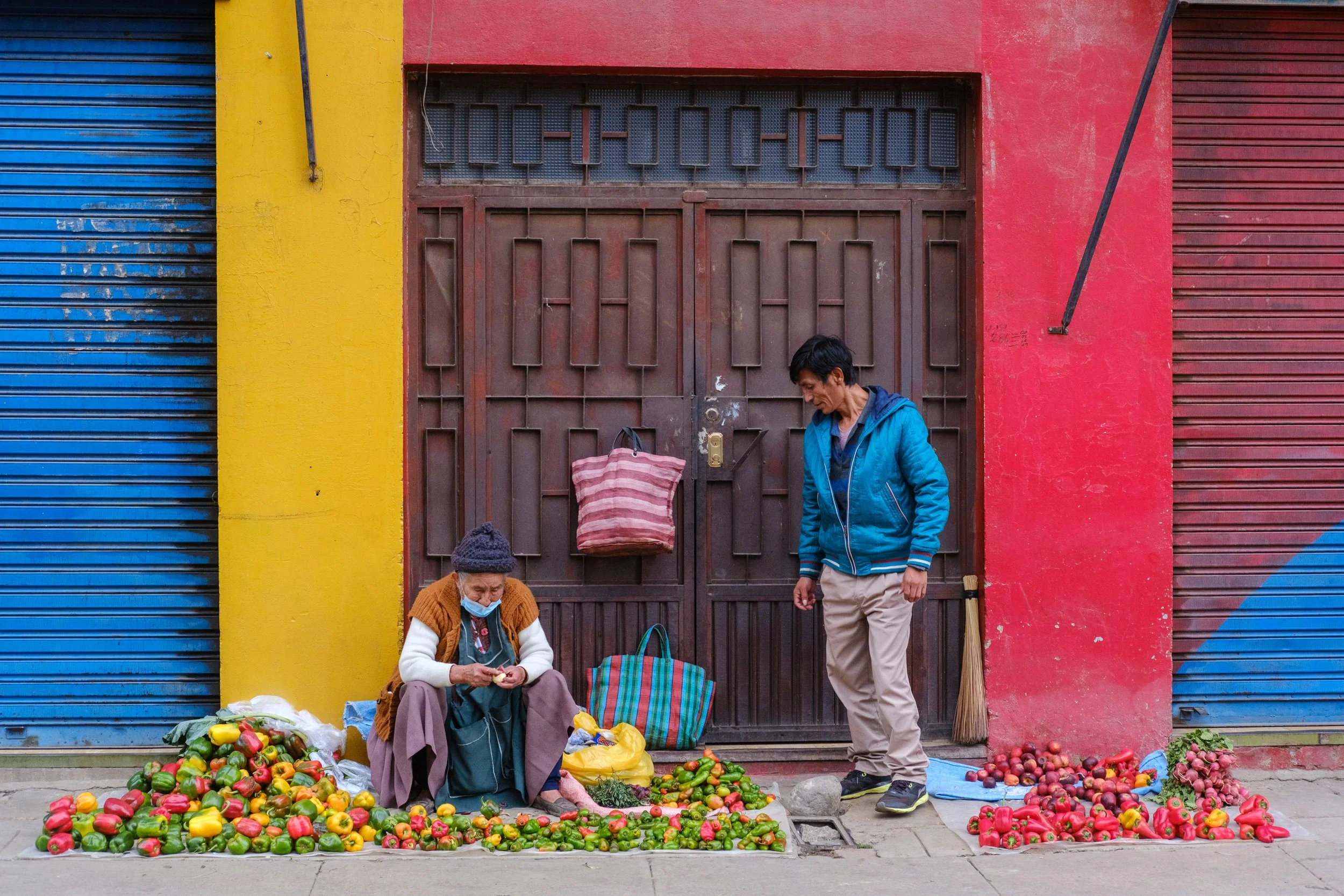 Chilli resellers in front of colourful building in Cochabamba market