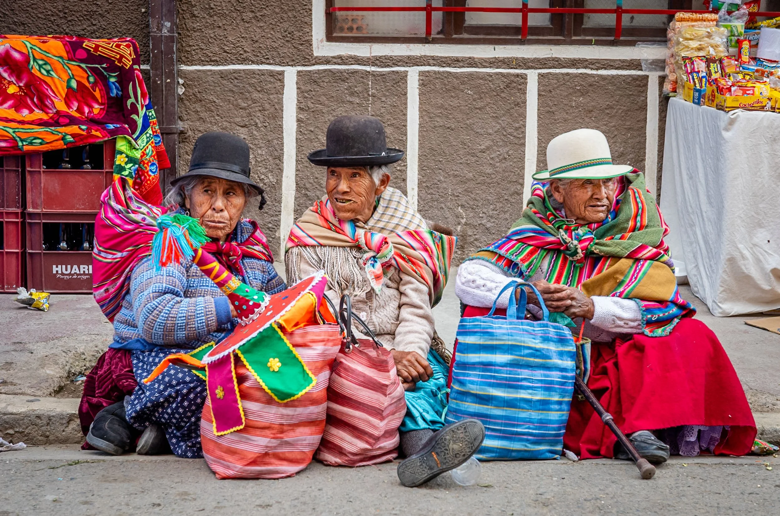 Three cholitas sitting in Oruro