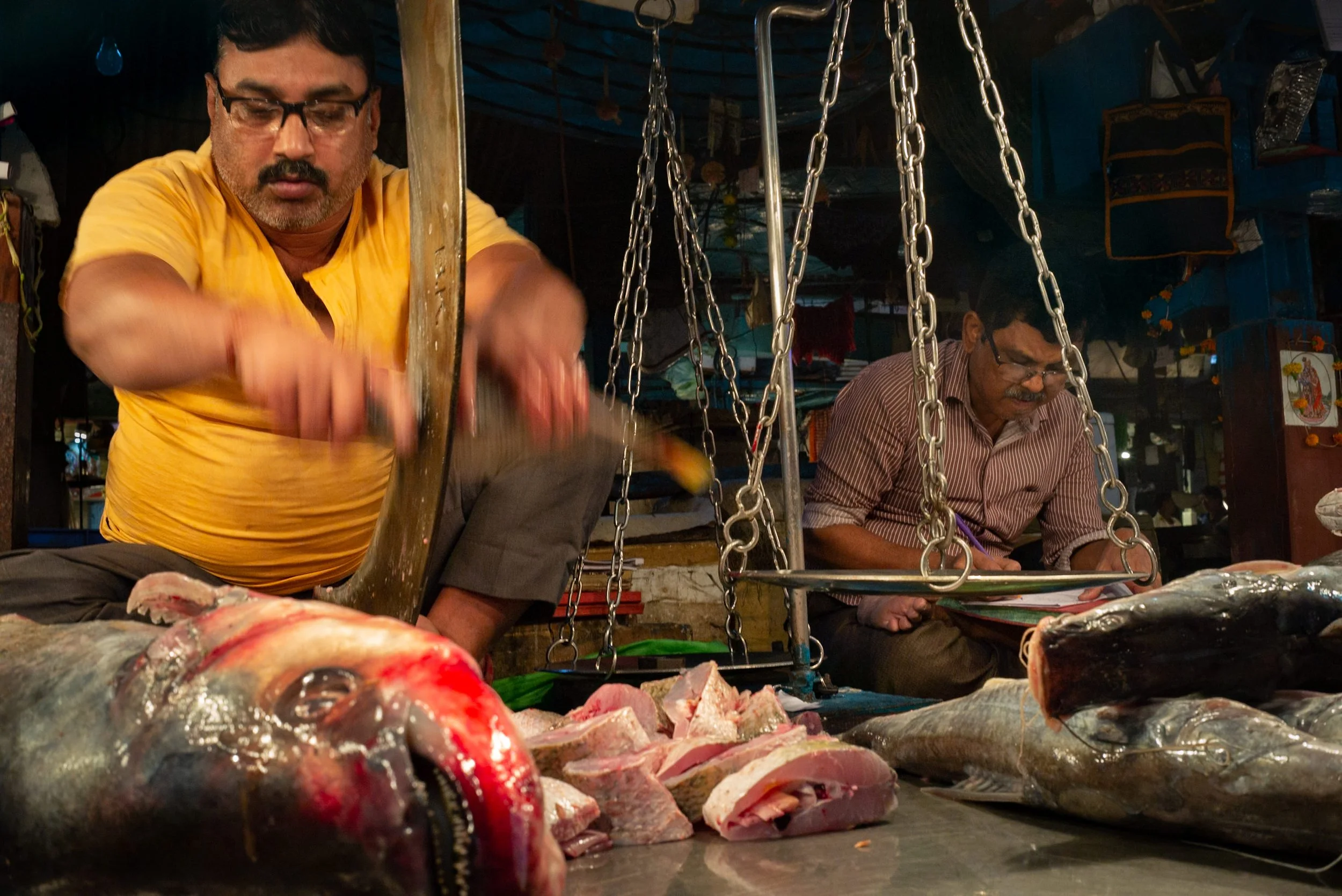 Fishmonger cutting fish in Kolkata fish market