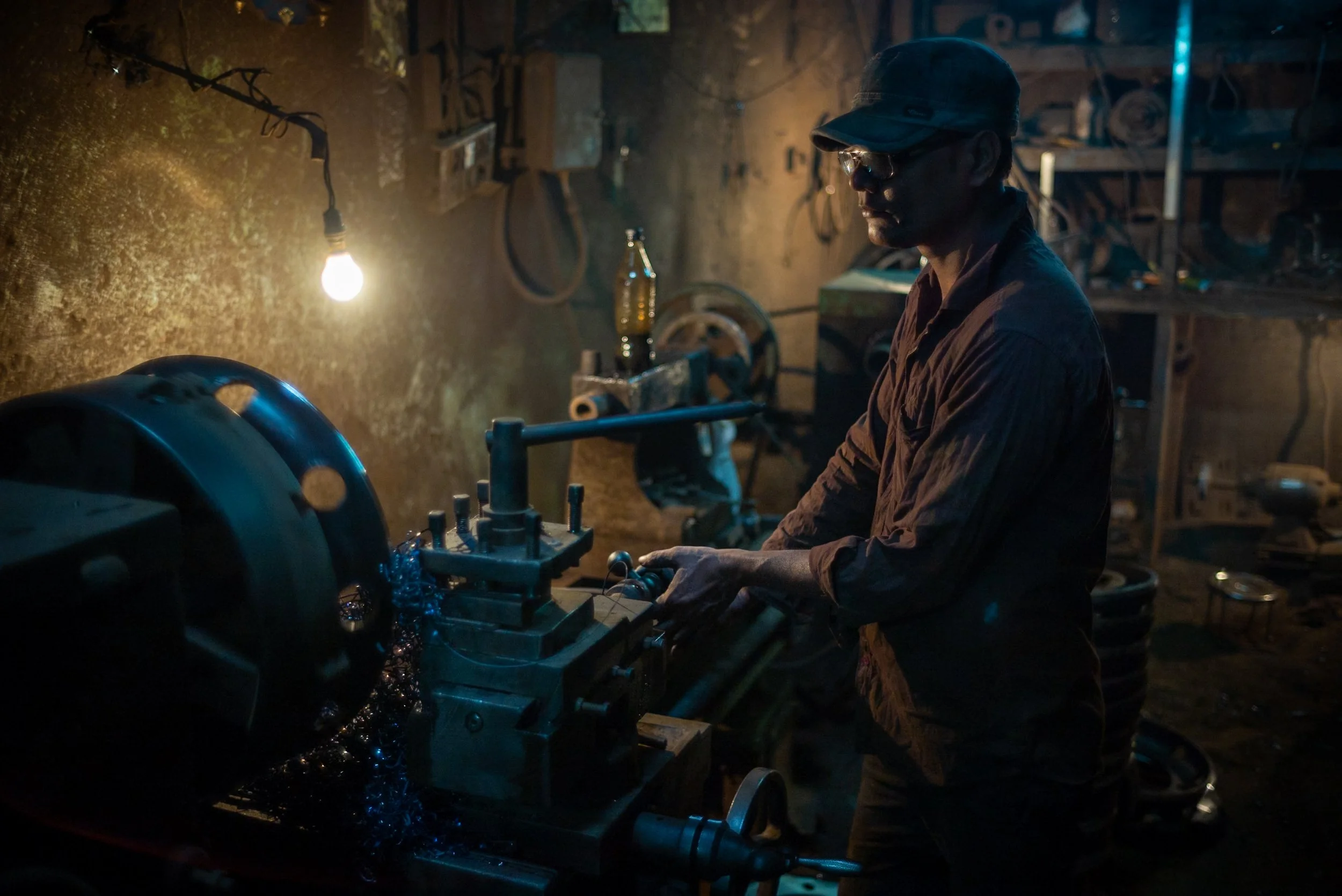 Portrait of man at work on lathe in Kolkata car parts market