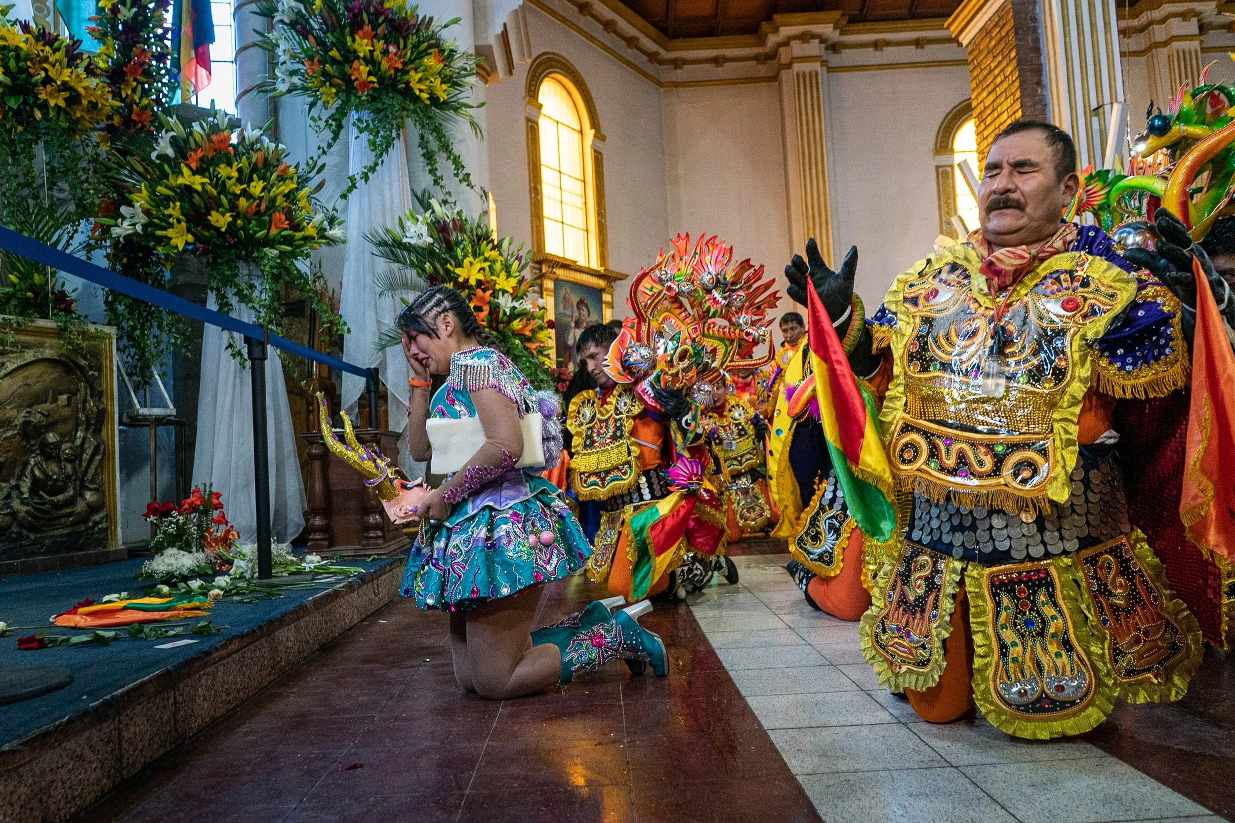 China Supay and Diablo masks kneeling in front of the virgin during the Peregrinación
