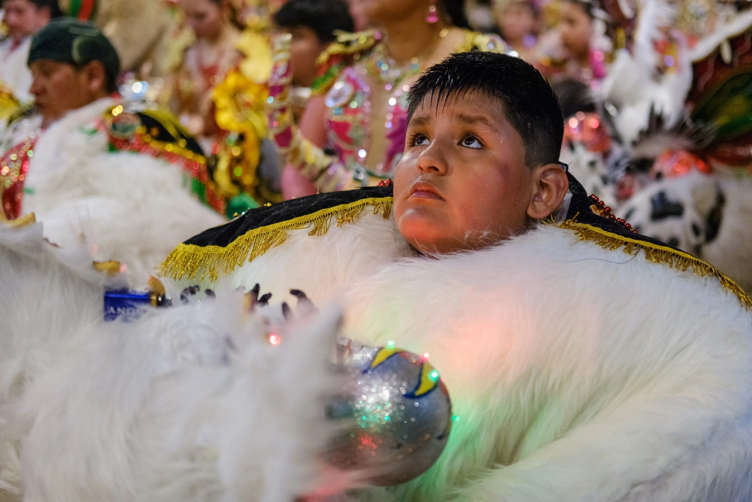 Child in bear costume listening to mass during the Peregrinación
