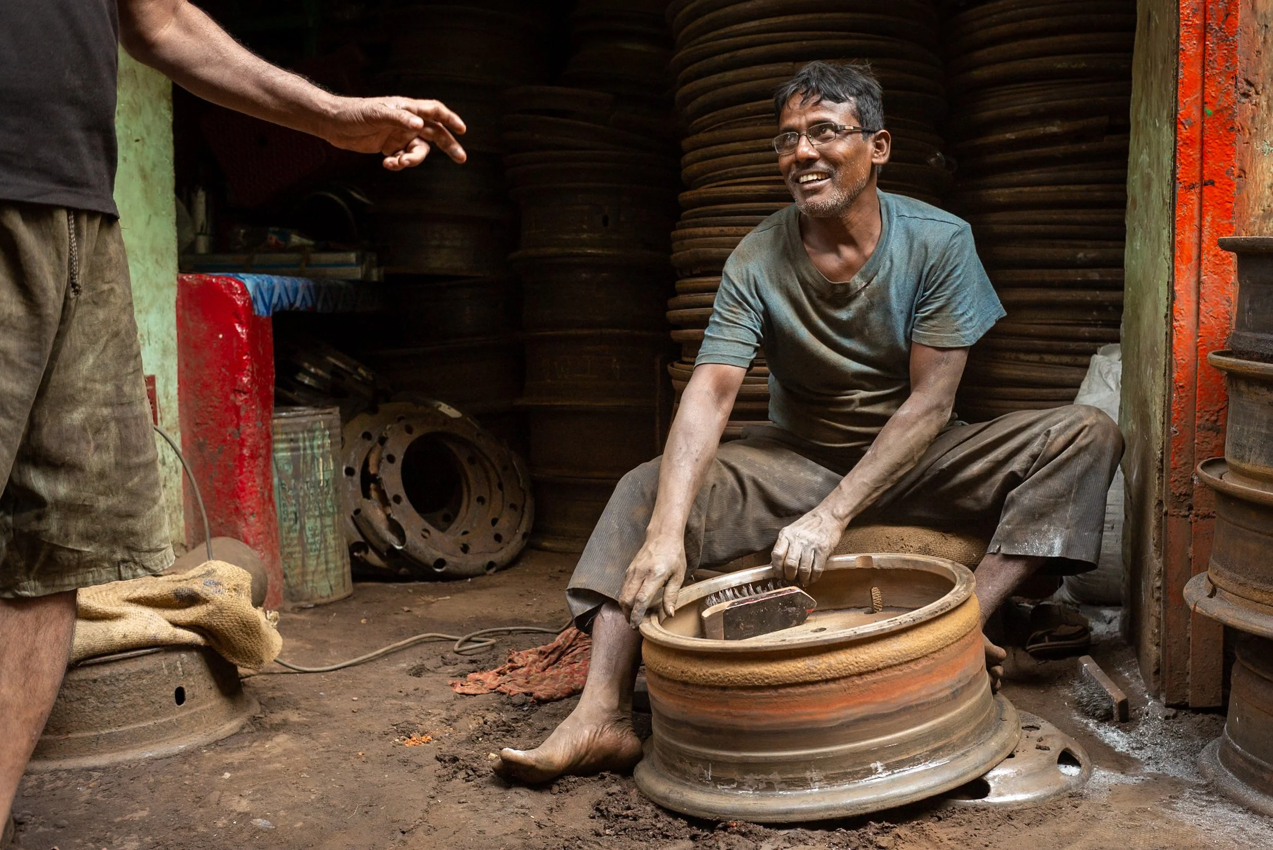 Portrait of man at work on wheel in Kolkata car parts market