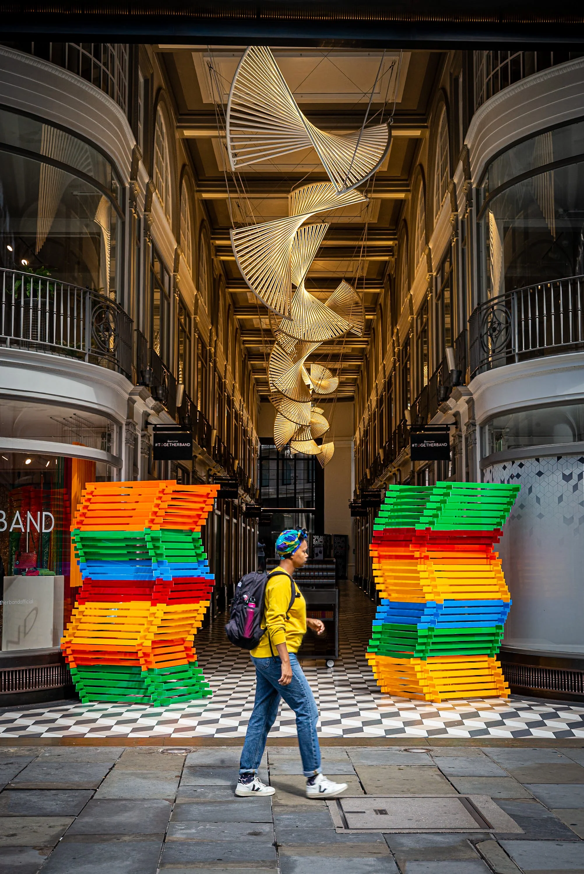 Woman walking between colourful stacks