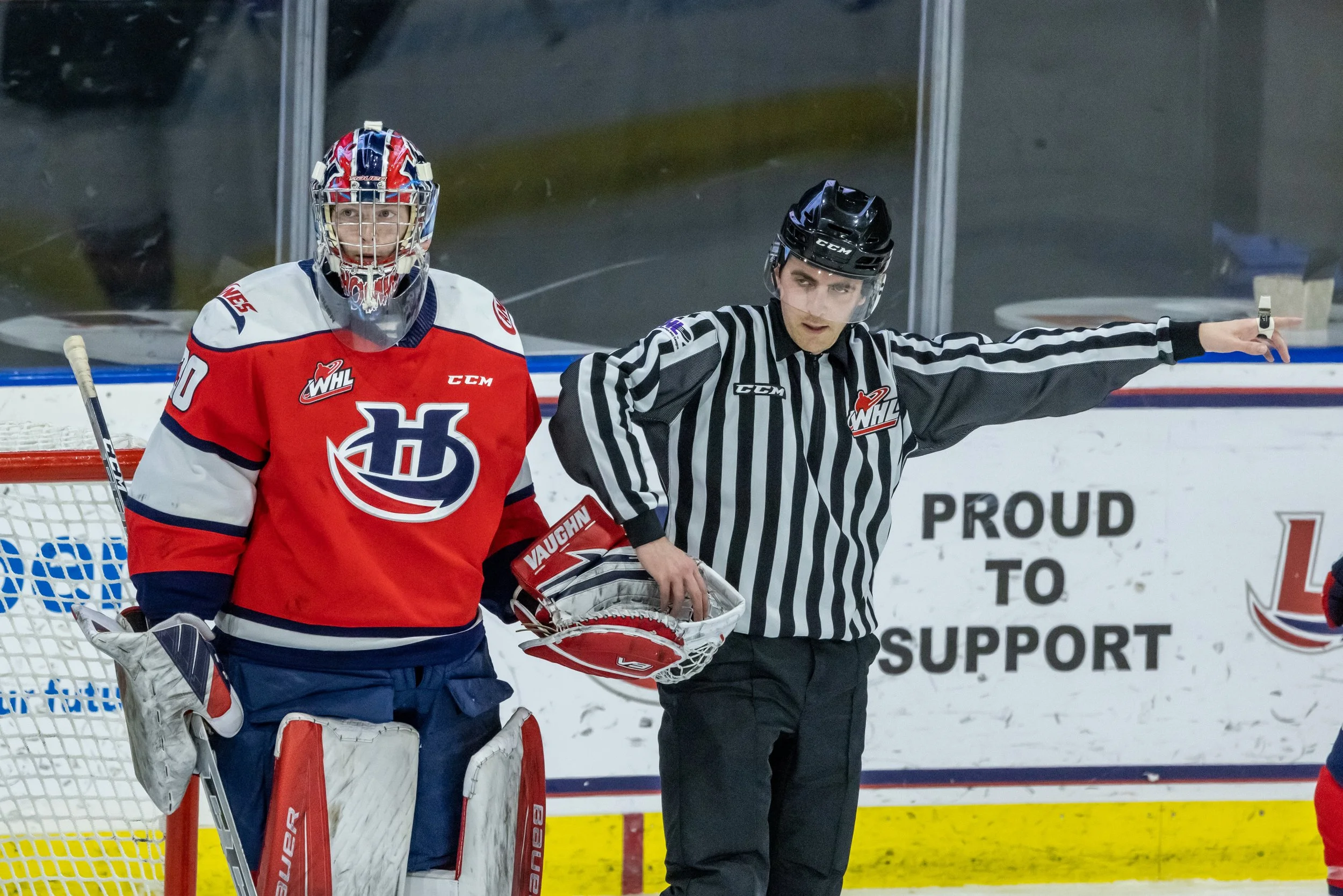 Lethbridge Hurricanes goaltender passes the puck to WHL official after the play
