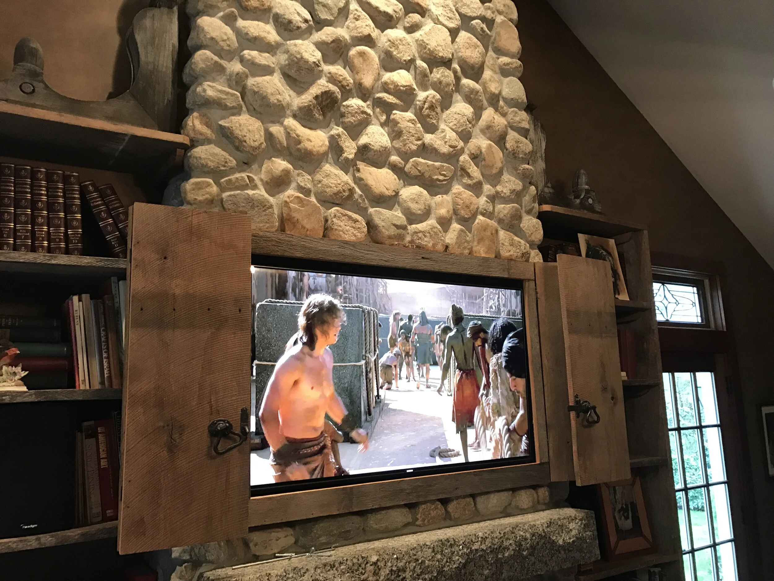 Custom-built recess in rustic fireplace, complete with hinged-shutter doors to conceal the TV when not in use (Weston, CT)