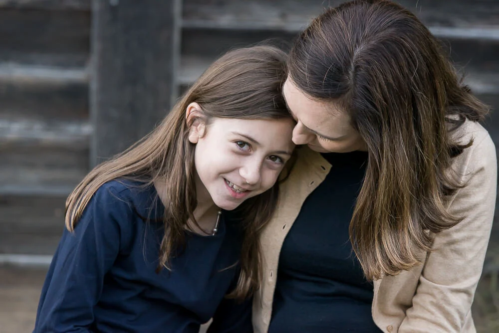 Tender mother-daughter moment with girl looking at the camera