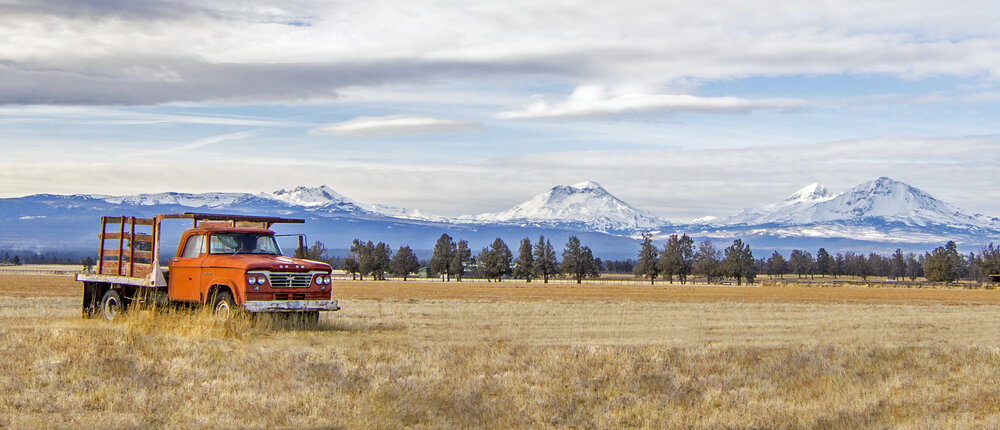  Photo by Claire Lavergne of an old Dodge truck with the Three Sisters Mountains just outside of Sisters, Oregon.  