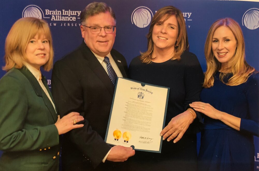  John is presented with a New Jersey Legislative Resolution commending him at a Brain Injury Alliance Gala. 