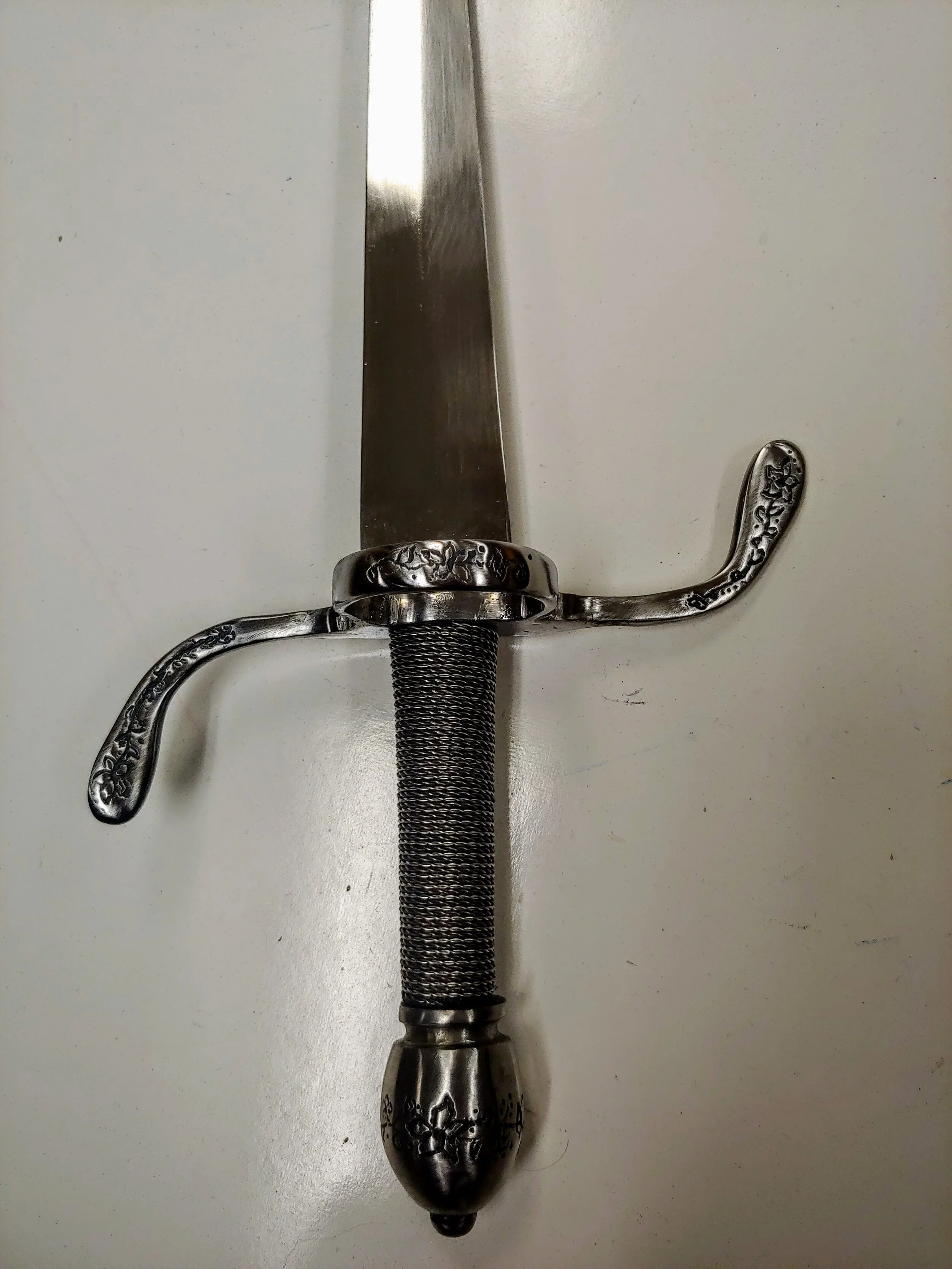 Dagger- Engraving done with a Dremel, handle is lathed and leather wrapped before being two-toned wire wrapped