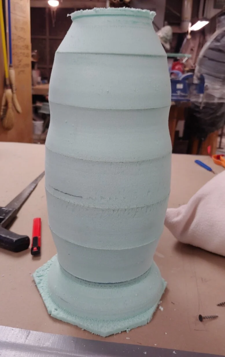 The initial form is layed up green foam that was lathed into shape