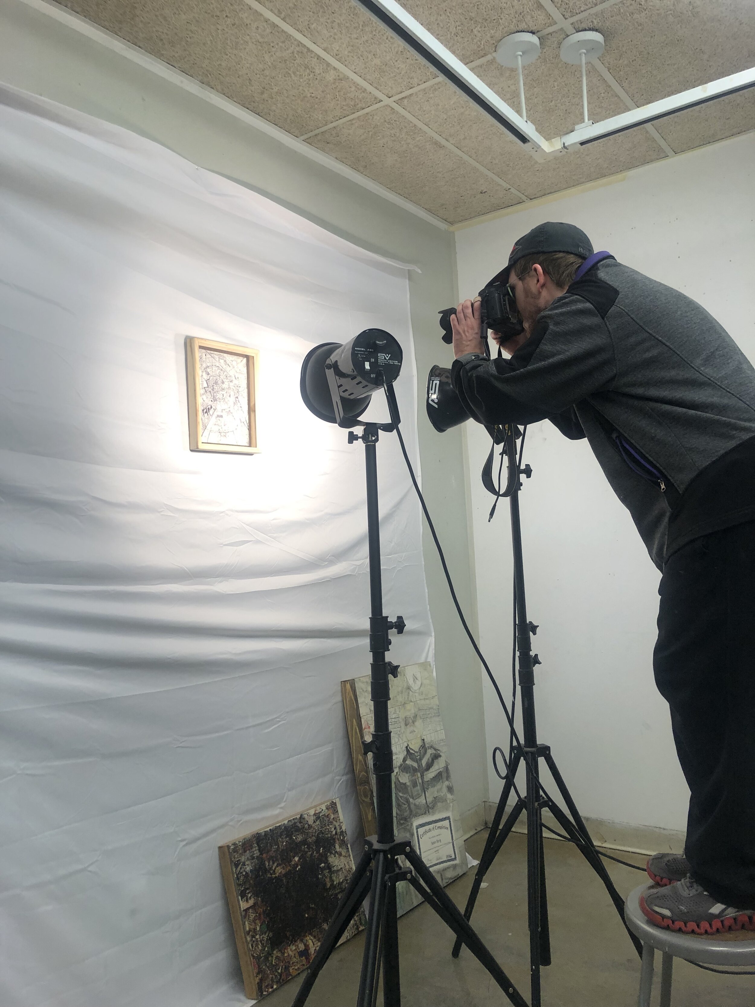 The artist taking pictures of the work for his website