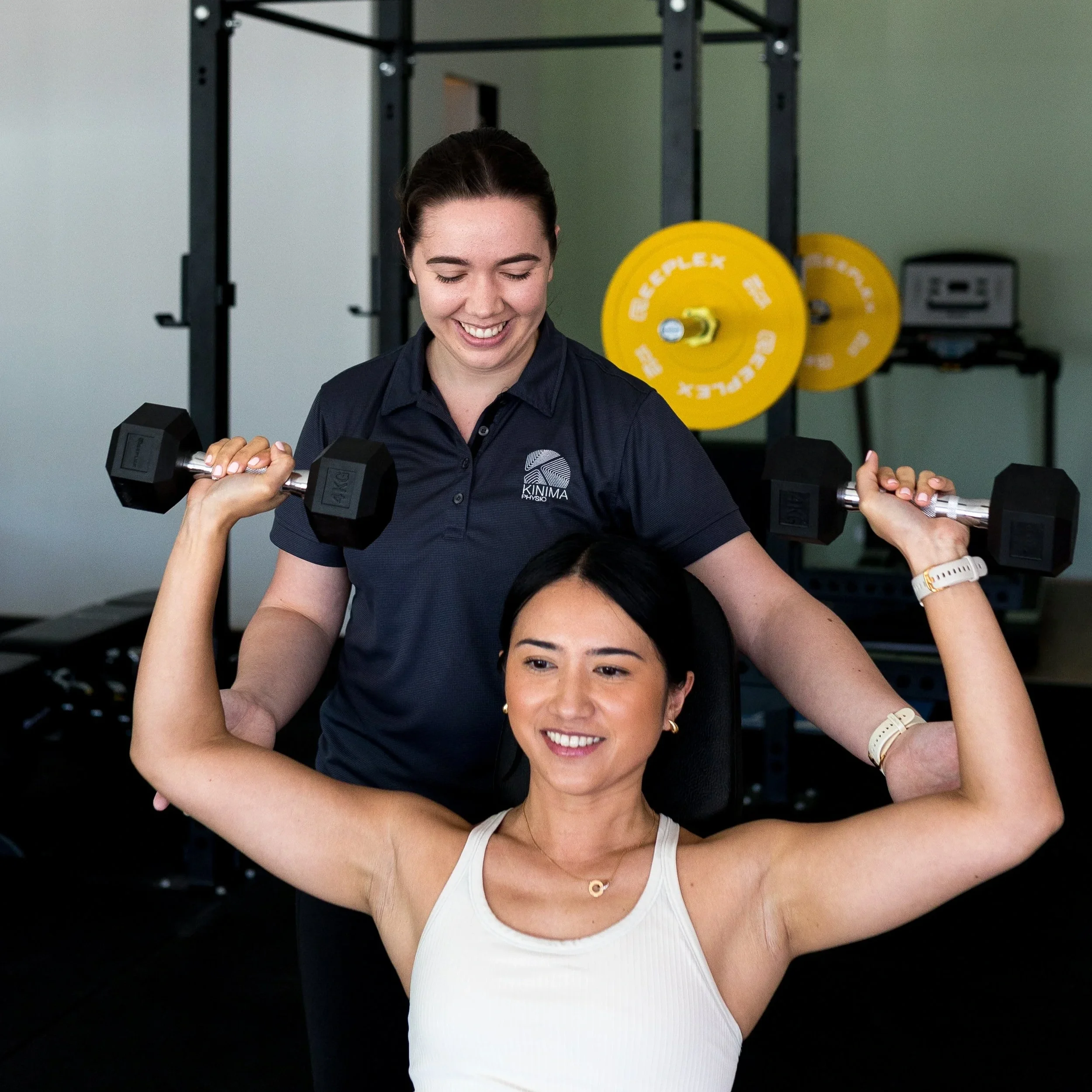 Physiotherapist supervising a client performing strength rehabilitation exercises during physiotherapy.