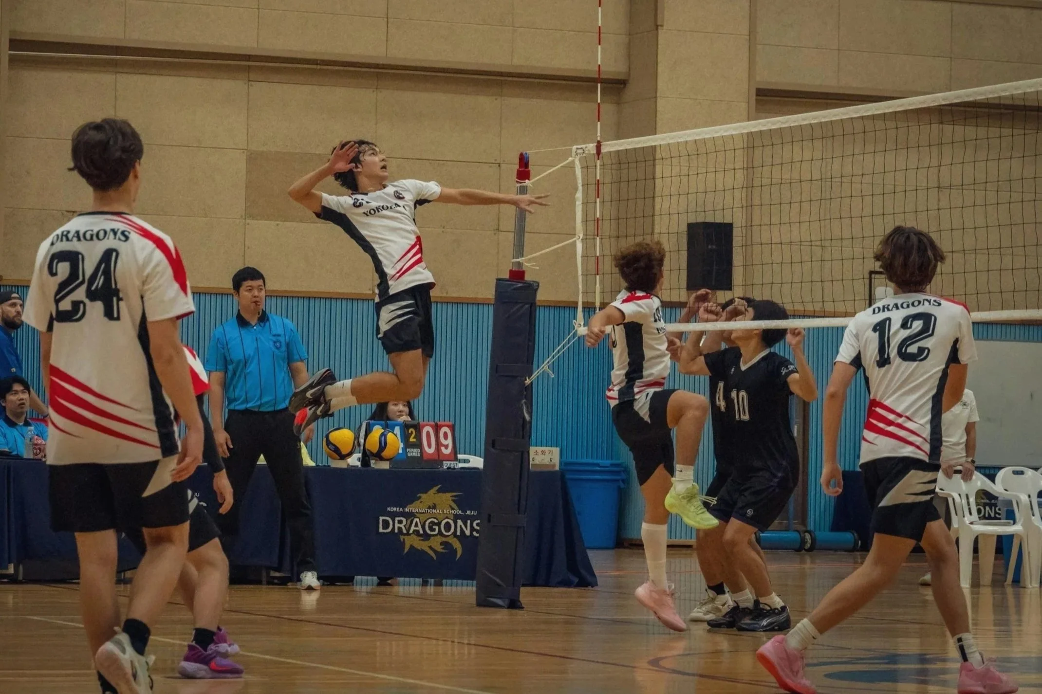 Volleyball player performing a jump spike showing overhead shoulder load during play