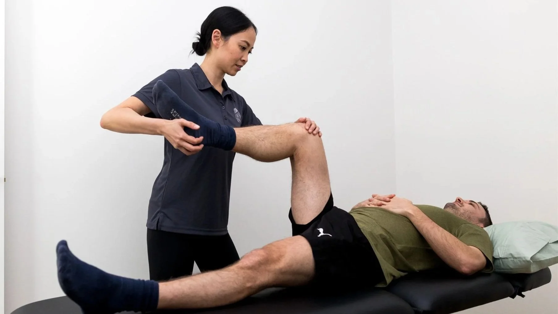 Female physiotherapist performing knee physiotherapy