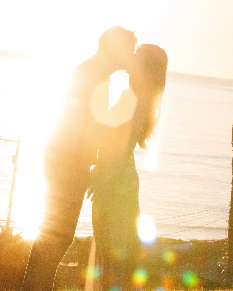 Hannah and Garrett silhouetted together in golden sunlight