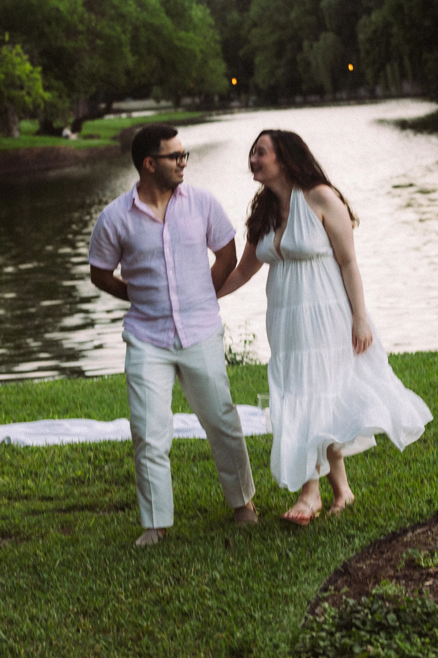 Shelby and Himanshu holding hands beside the water after their Central Park proposal