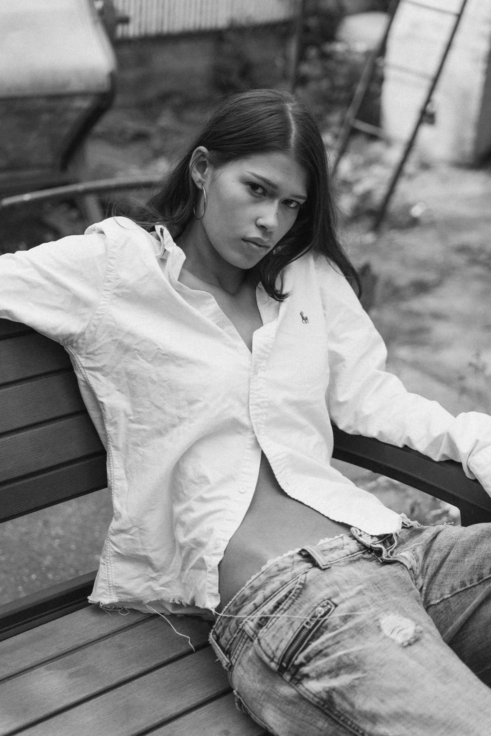 Black-and-white portrait of a model wearing a loose white shirt and jeans