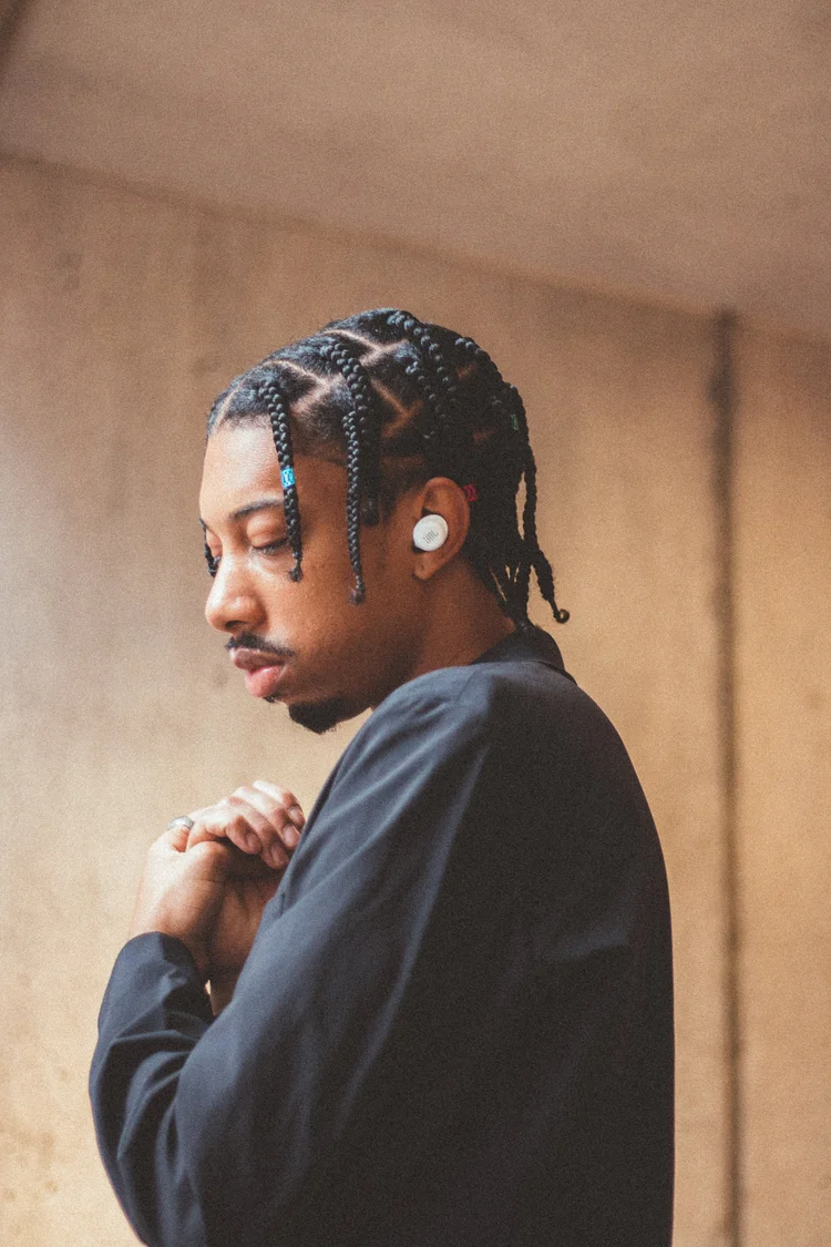 JBL lifestyle portrait showing a man wearing white wireless earbuds