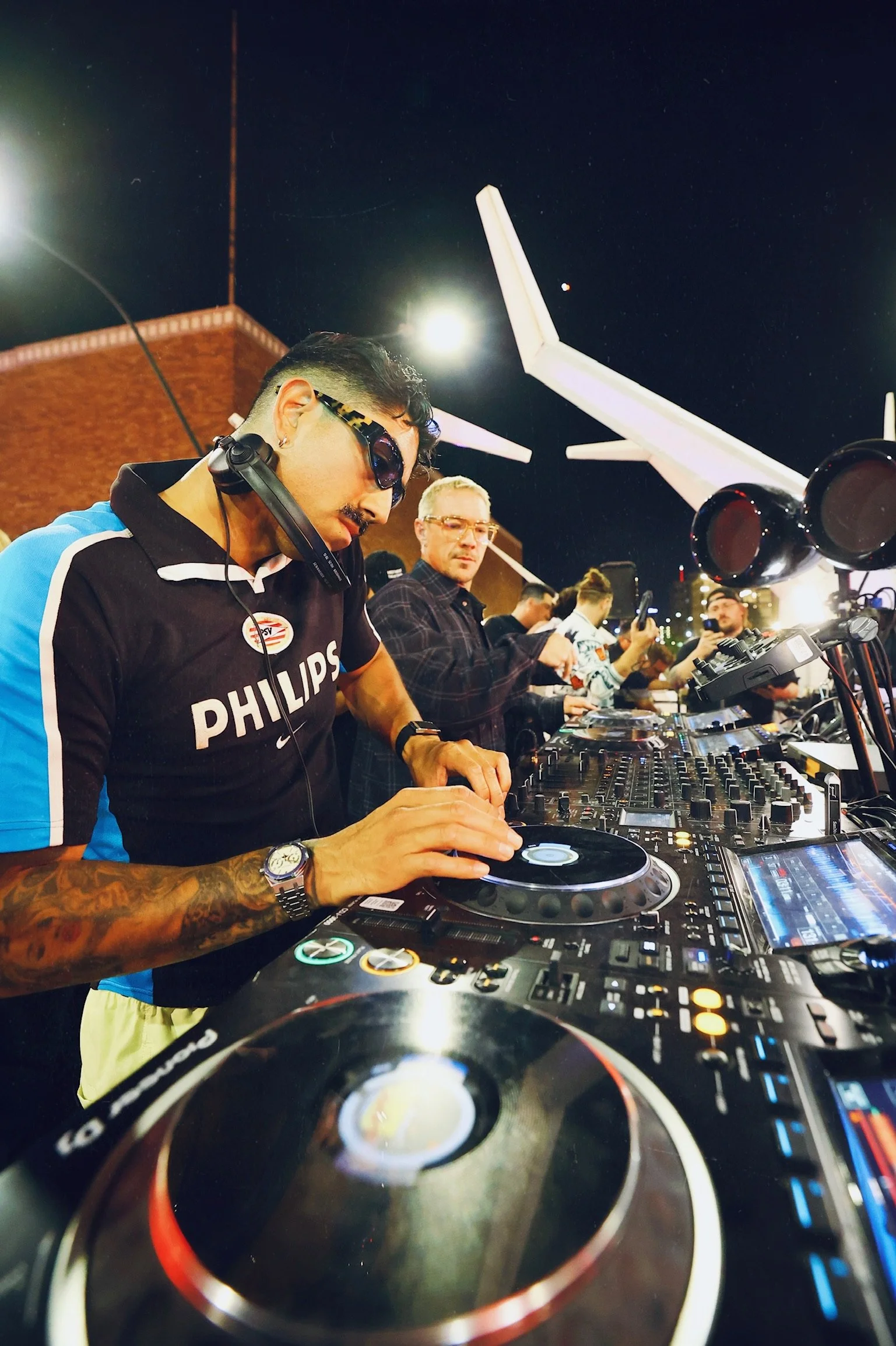 Major Lazer performing live in Downtown Las Vegas, featuring Walshy Fire engaging the audience from the DJ booth during a high-energy 'Feed The Block' set.