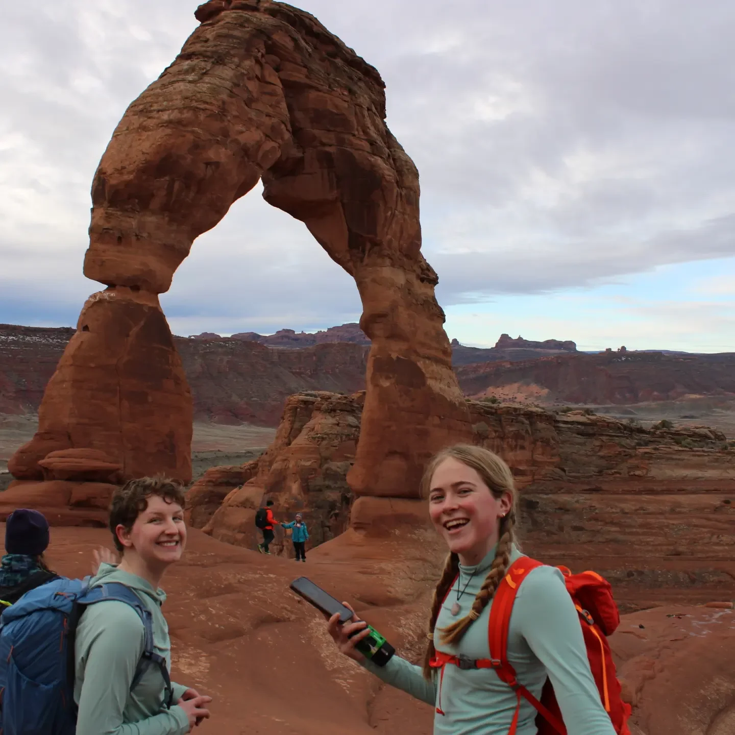 Ana Mathers posing with a friend for a photo in front of the Delicate Arch at Arches National Park