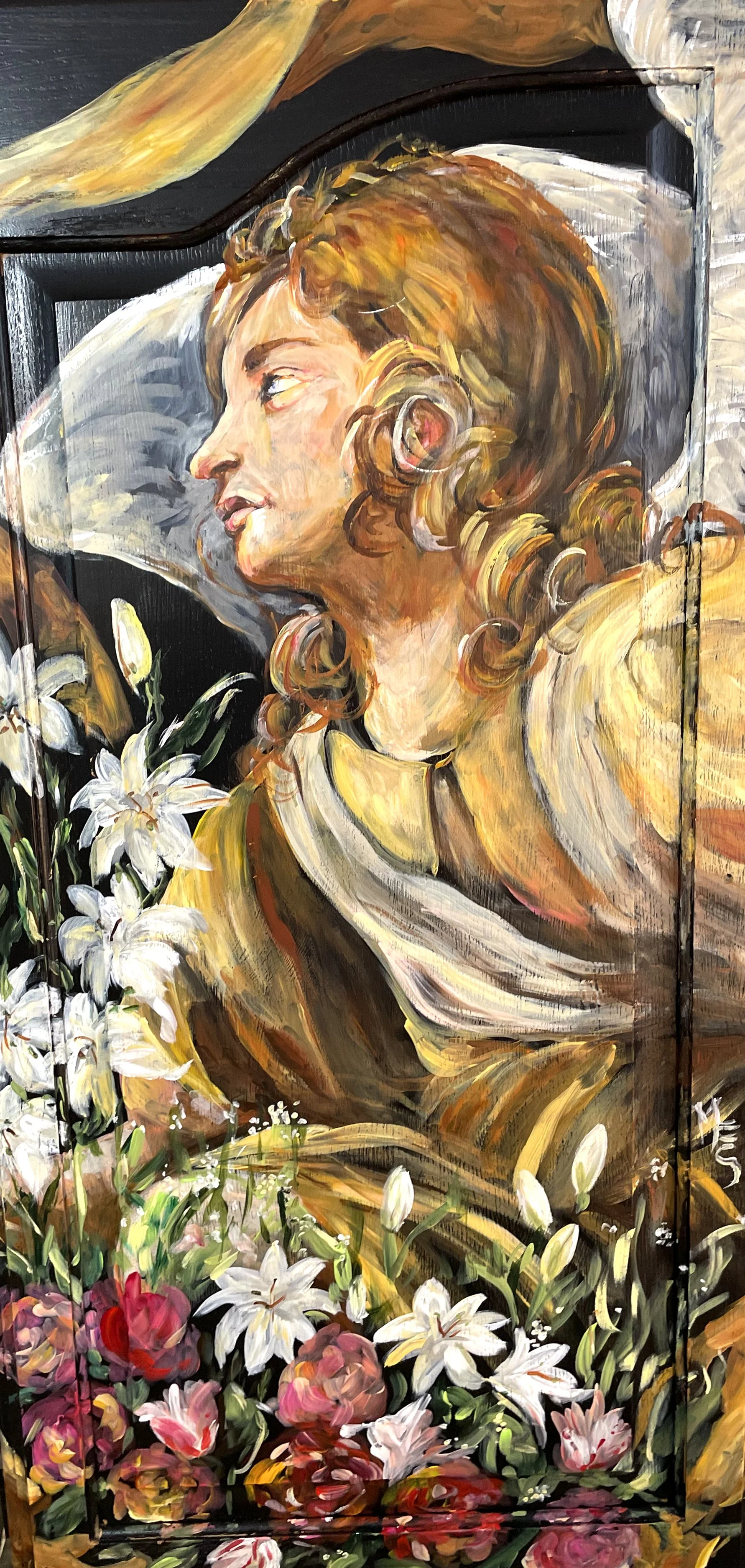 A painting of an angelic figure with flowing hair, surrounded by white lilies and roses. The angel appears to be gazing upward, depicted in warm tones against a dark backdrop.