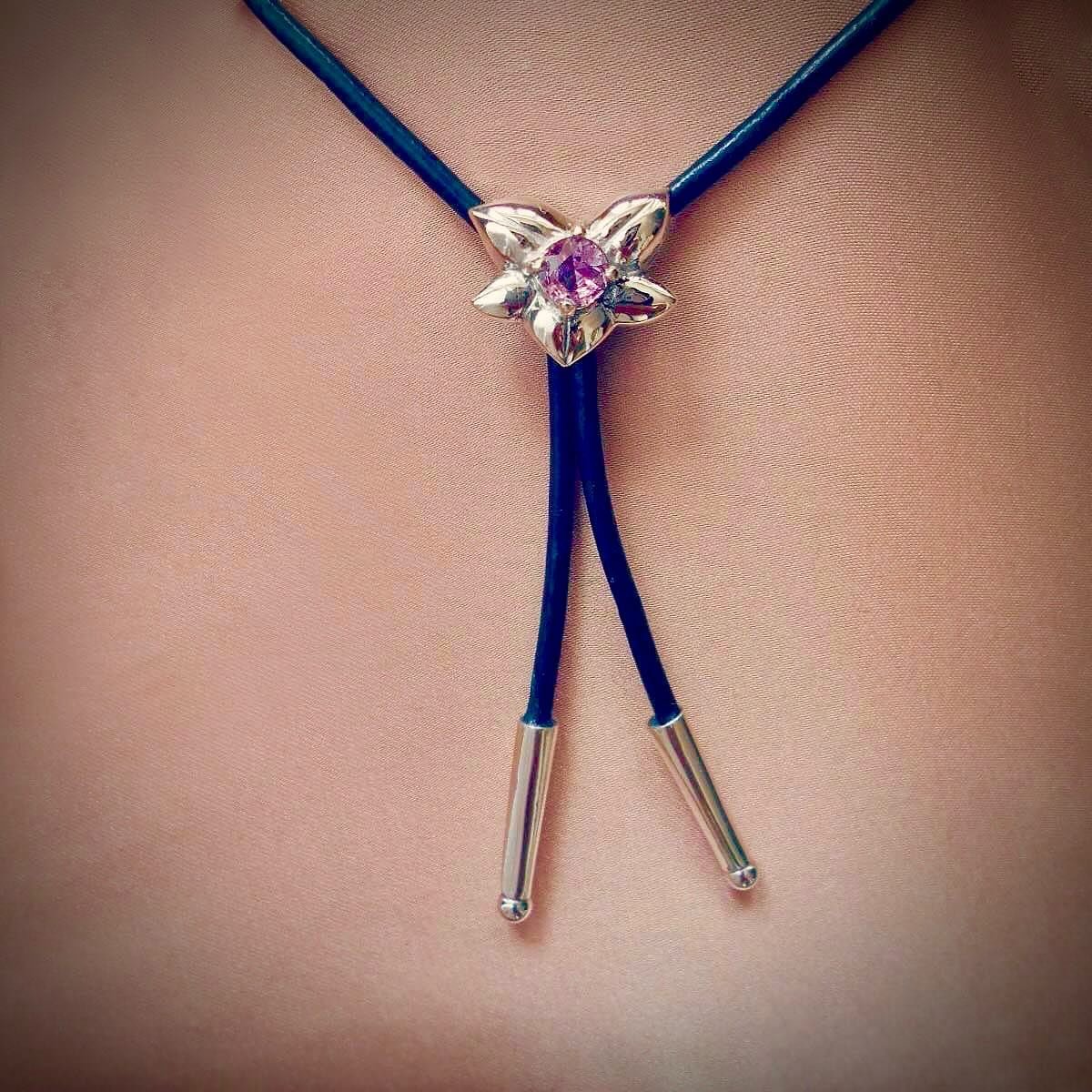 To mark the arrival of spring, as the evenings draw out, I was inspired to celebrate by making a dainty flower bolo tie necklace. Set with a delicate pink sapphire on a silver tipped cord, wear it short like a choker or long - or somewhere in between
