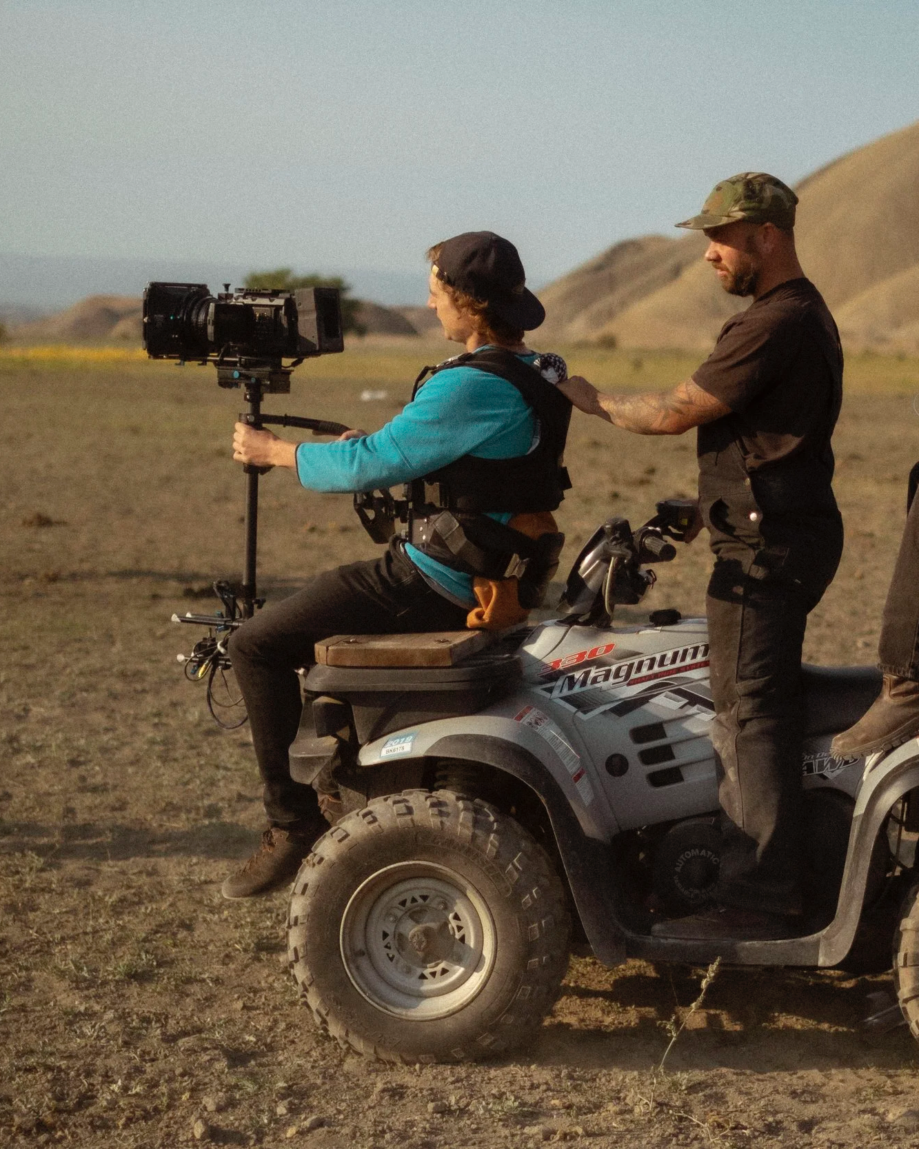 Camera operator filming documentary-style brand footage from an ATV during an outdoor production.