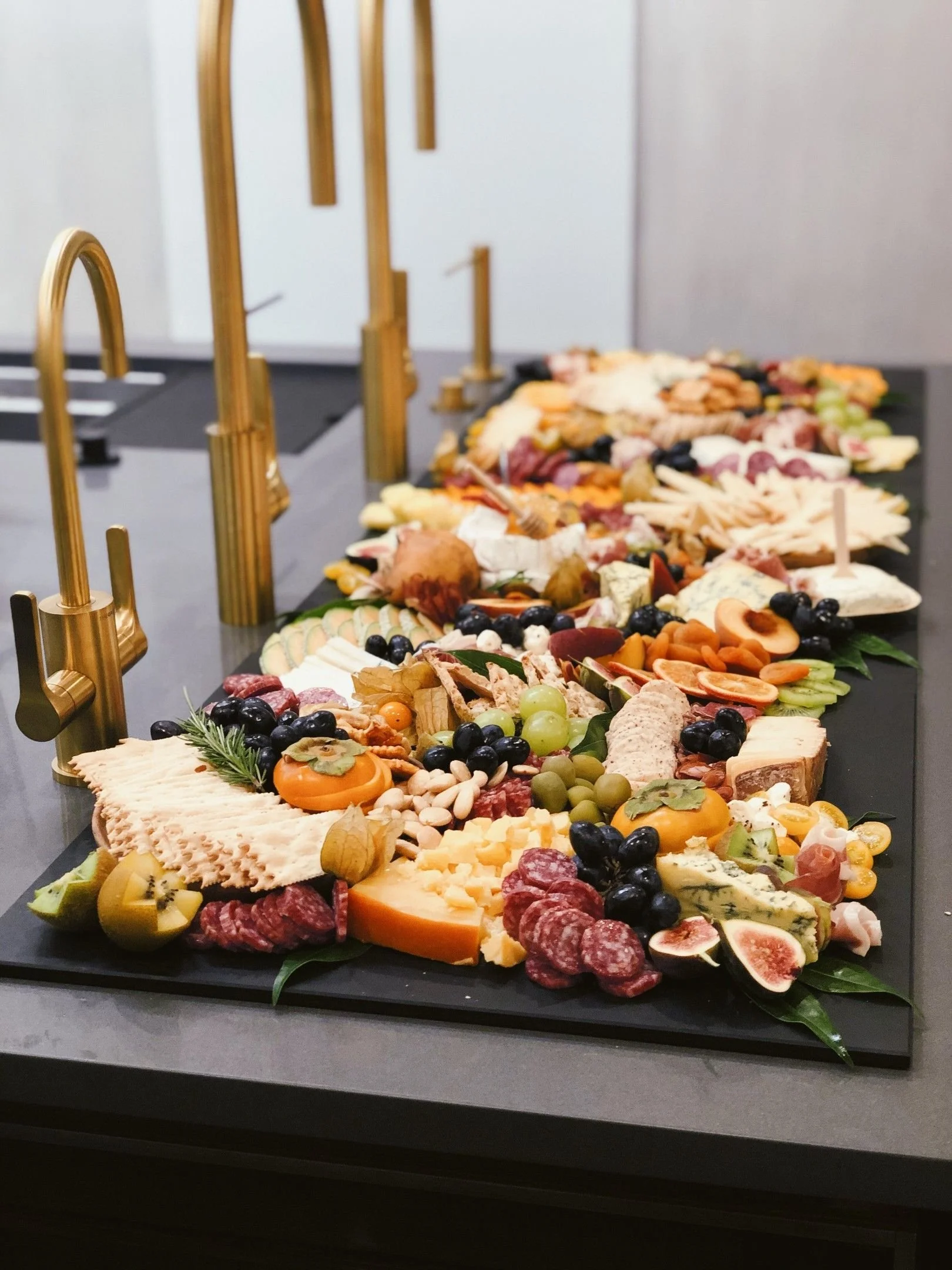 Charcuterie-Spread-on-Complete-Upper-Deck-Set-on-Galley-Workstation-5S-with-PVD-Brushed-Gold-Taps.jpeg