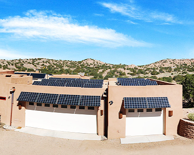 A home with solar panels on the roof in a desert New Mexico landscape.