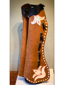 Retro Batwing Made from suide cow hide featureing an old time square basket stamped belt. Five conchos with black strings holding the rings. The outside of the leg is hand laced in cream. Our retro design is featured under the belt and on the wing ti