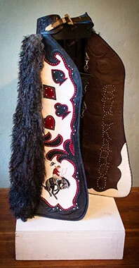 This pair of angor chaps feature some of the finest natural dark twisted angora. The wings are top-grain Italian ivory leather accented in black and red trim. The buckaroo was hand painted. This pair features over 1,000 hand set spots. Note the insid