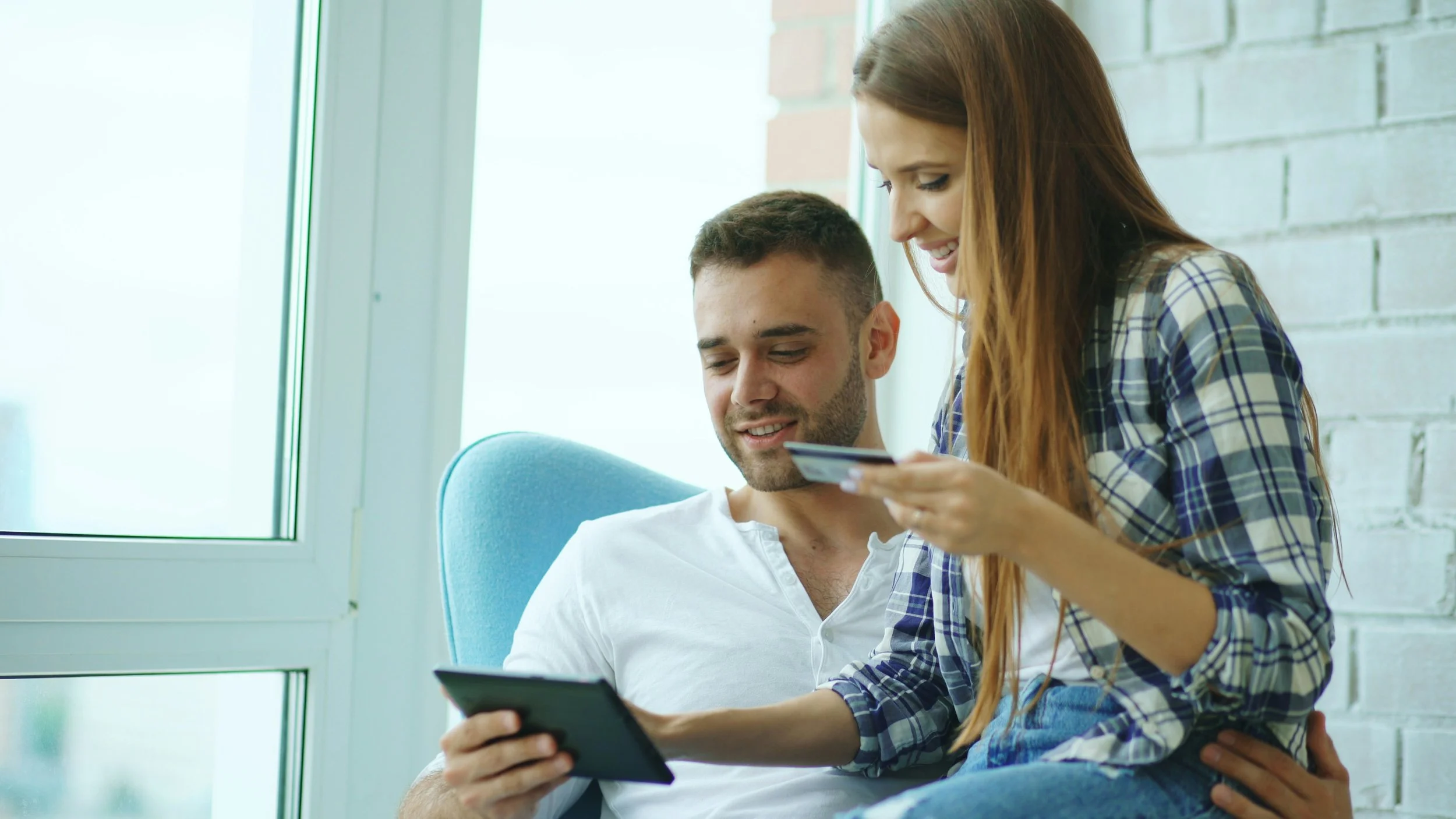 Couple sits together working on their financial goals.