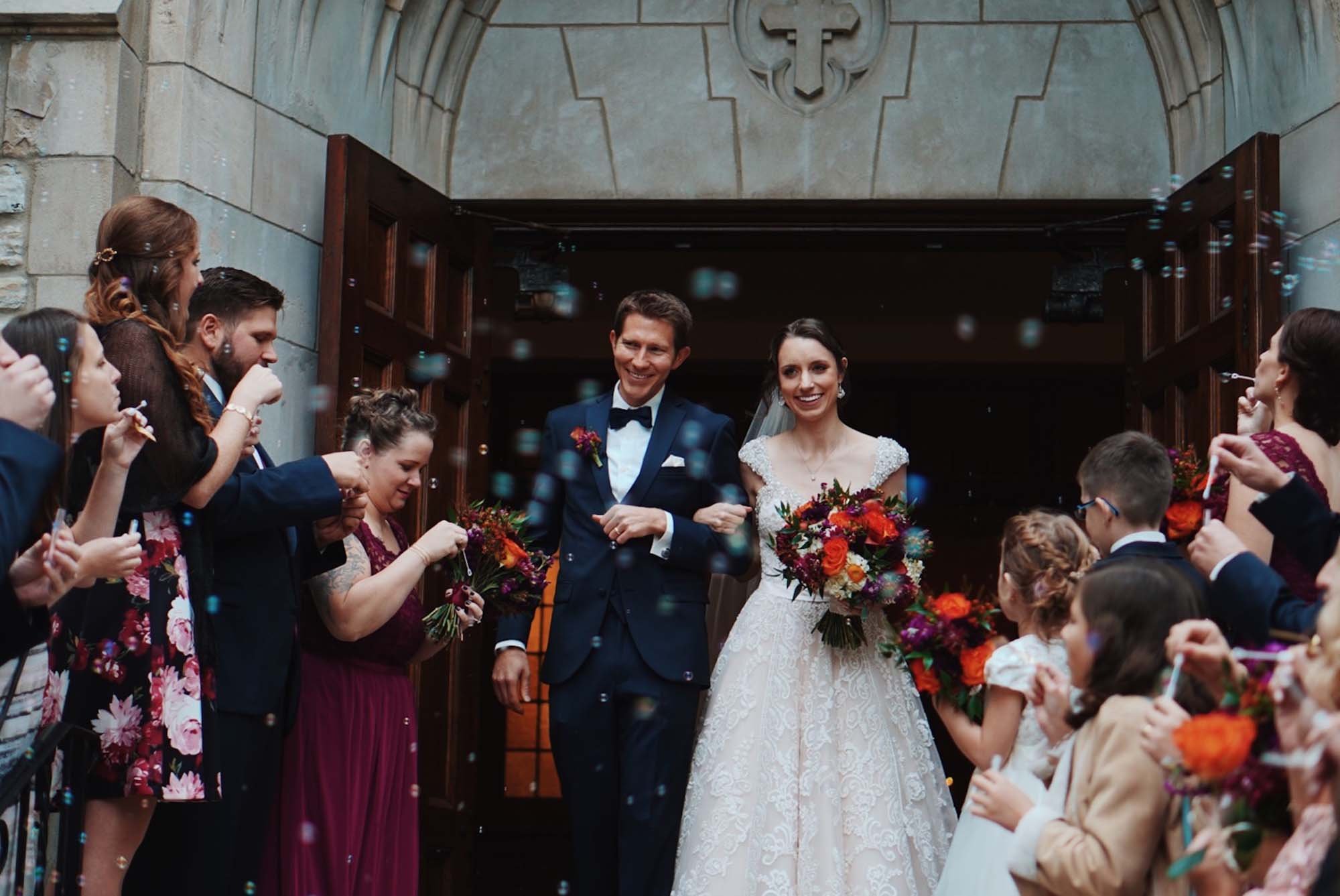 A couple walks out of a church immediately after their wedding ceremony