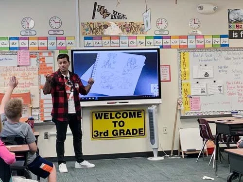 Ivan Castro teaching a clothing folds and wrinkles art demo at an elementary school