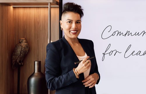 Sharon Parkir standing in a boardroom environment and smiling while conducting a Corporate Training exercise