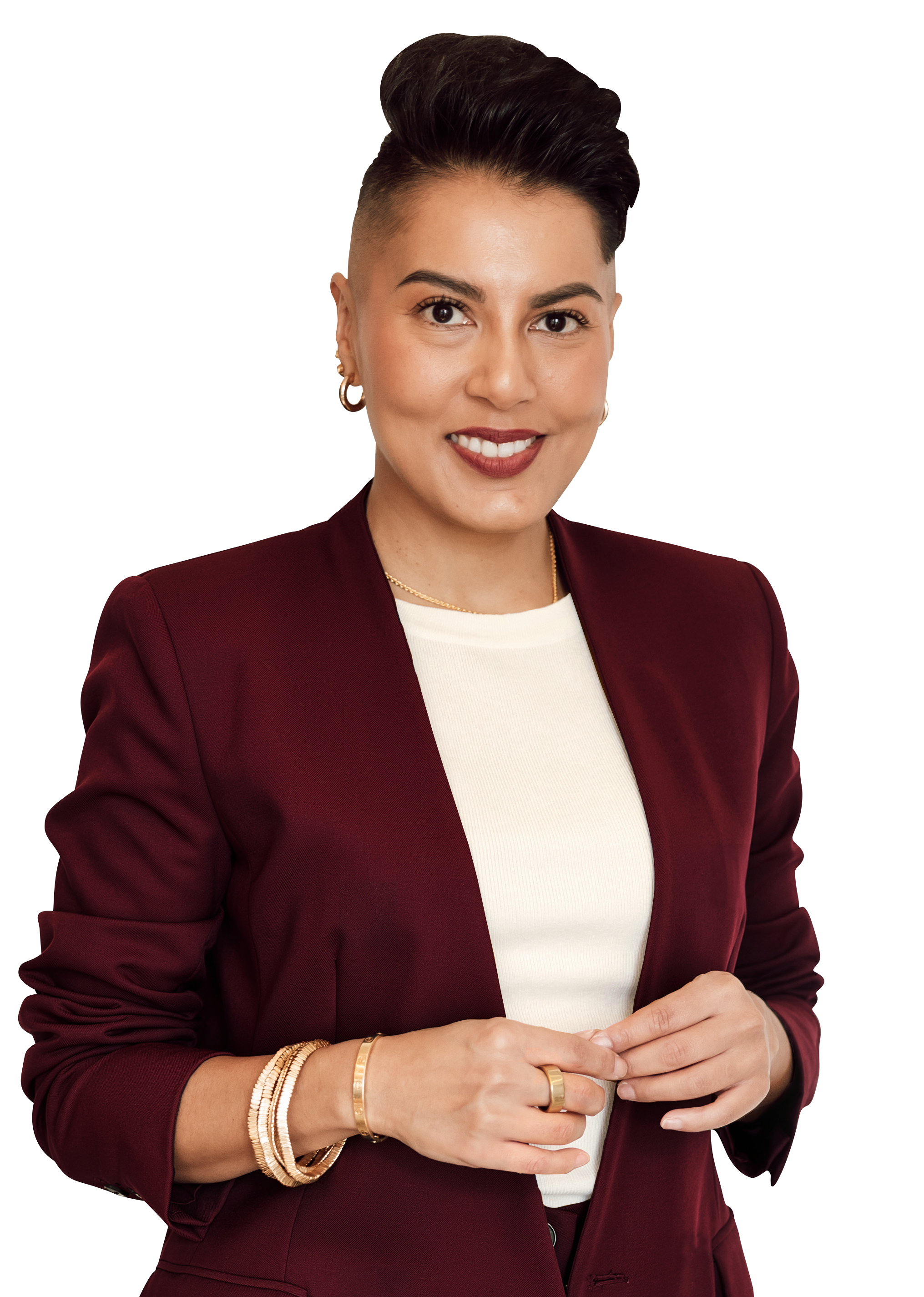 Sharon Pakir standing in a burgundy suit looking directly at the camera and smiling