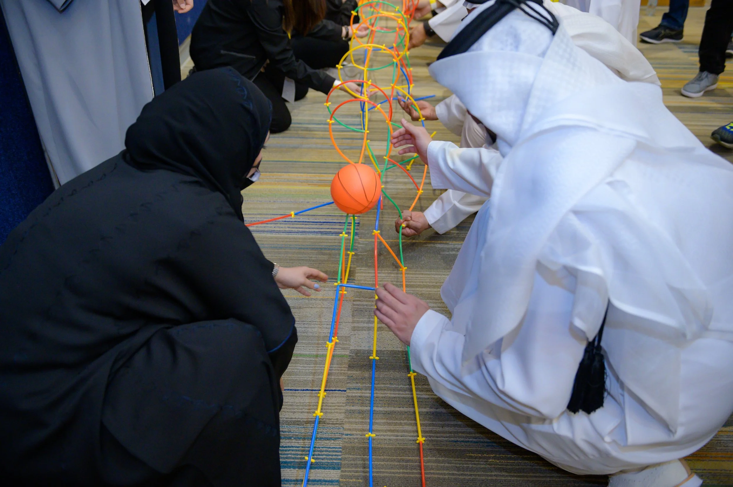 A group of participants working on a team building task in the UAE